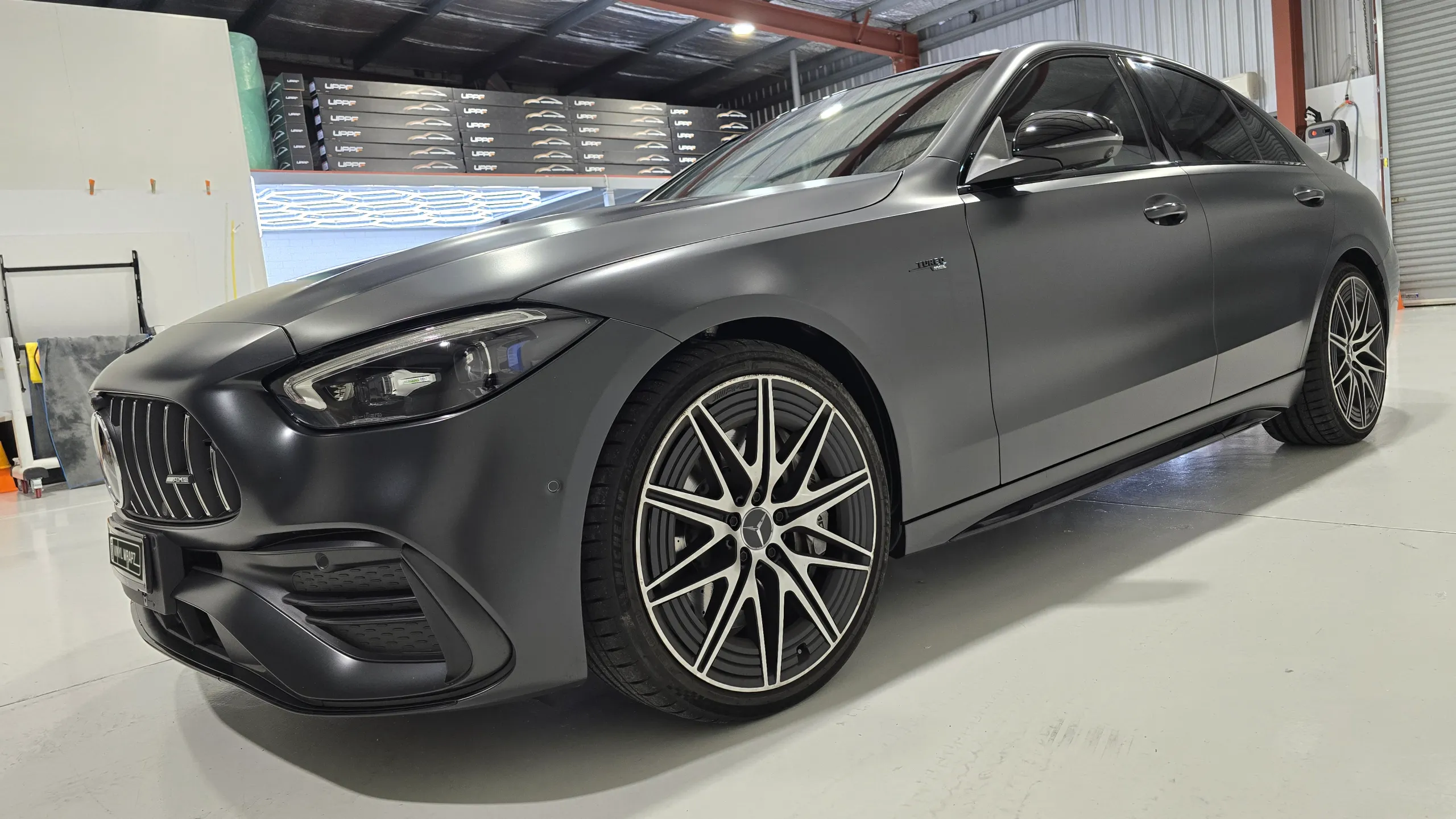 Front-quarter view along the satin dark grey Mercedes-AMG C43 side panels