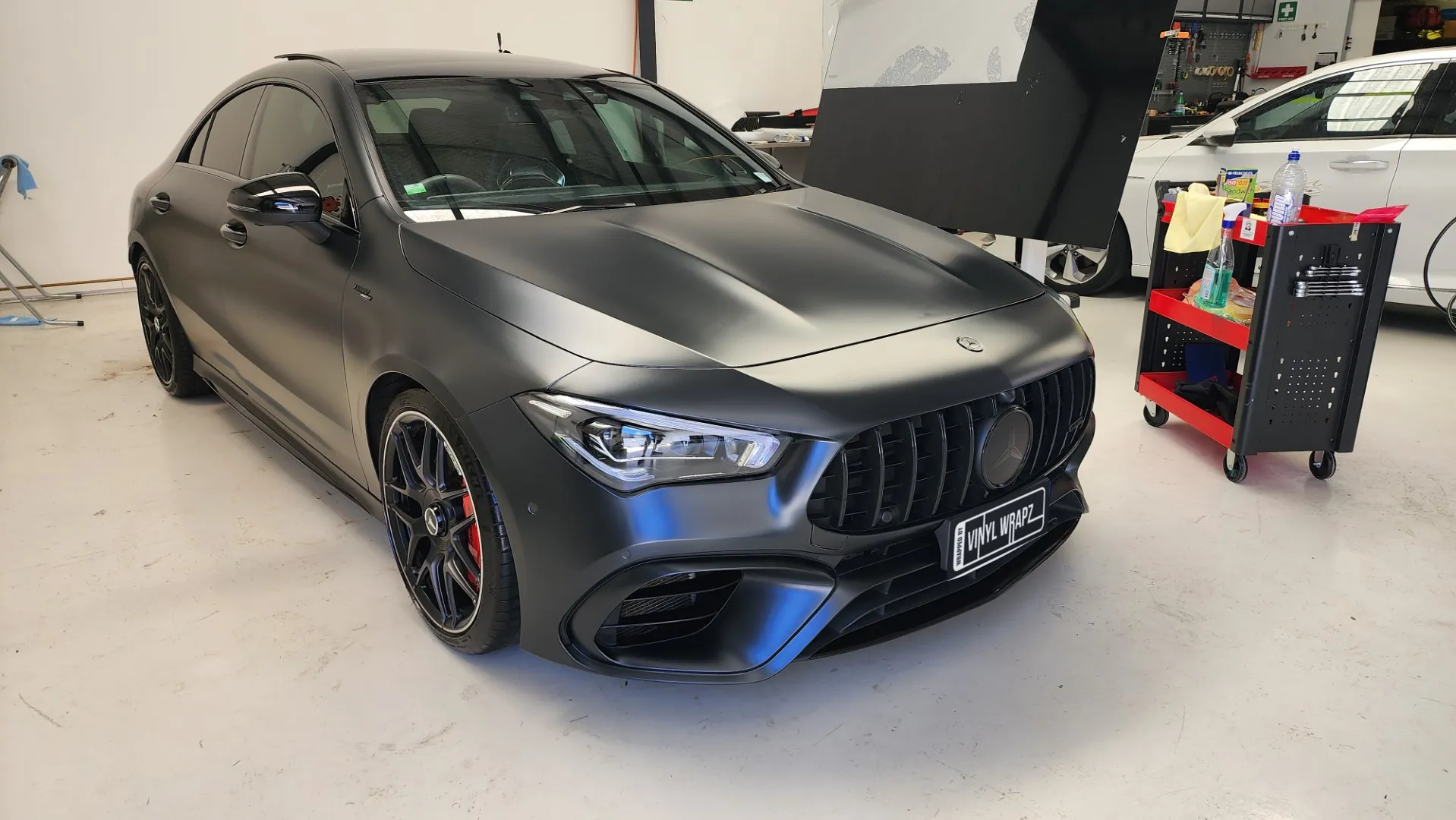 Satin dark grey Mercedes-AMG CLA 45 S viewed from the front quarter in the workshop