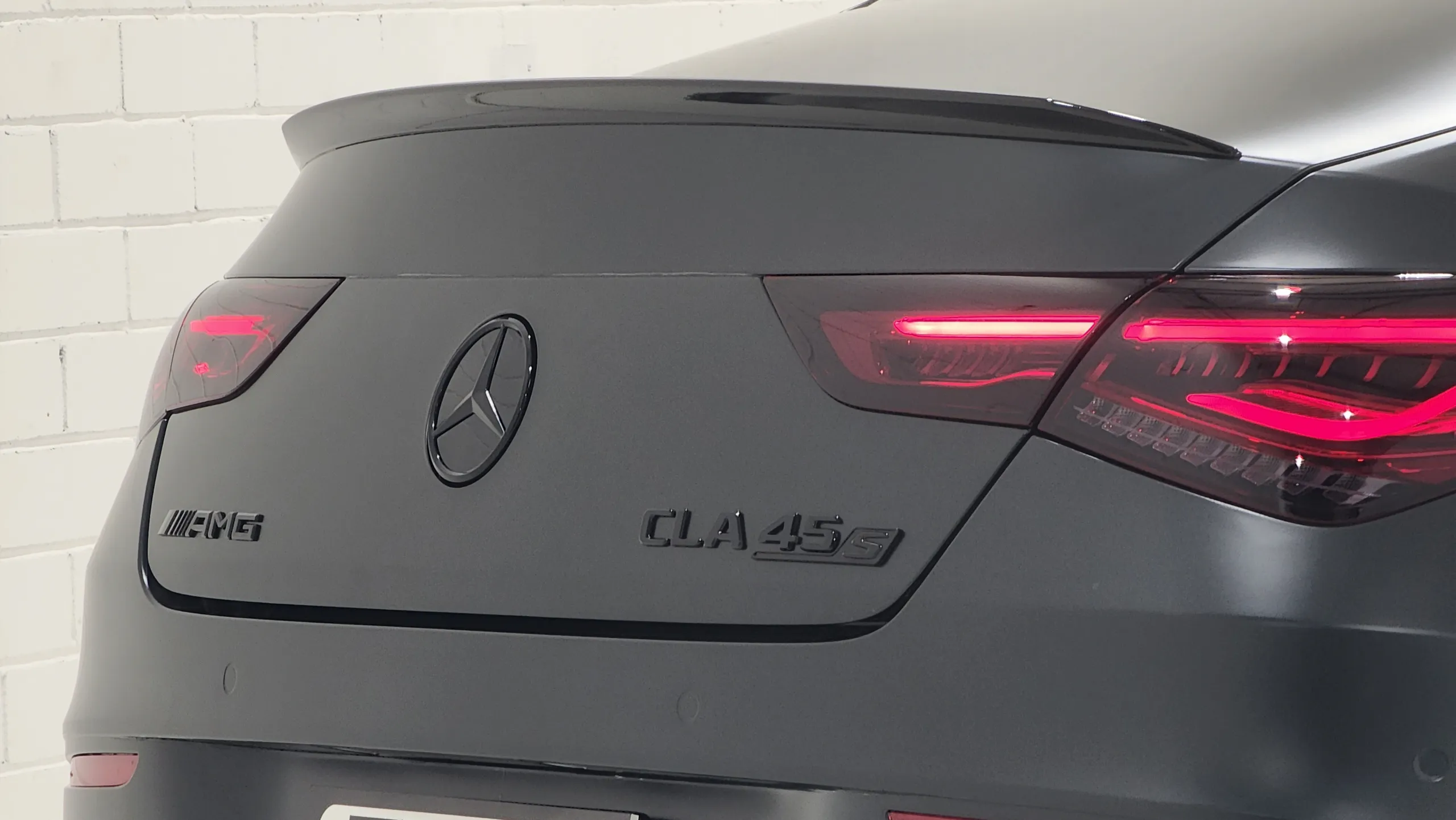 Black AMG and CLA 45 S badging across the satin dark grey boot lid