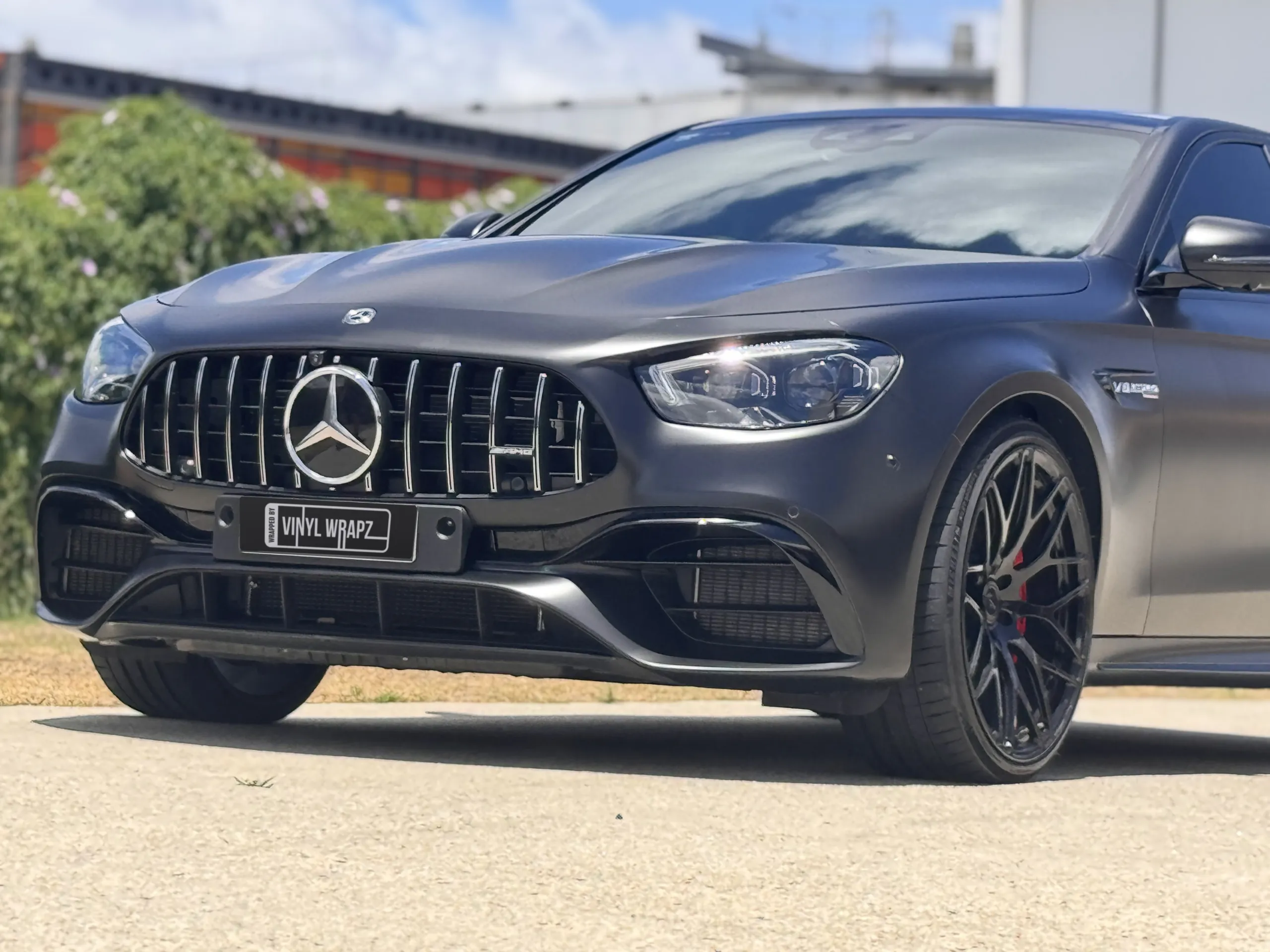 Satin black Mercedes-AMG E63 grille, headlight and front wheel outdoors