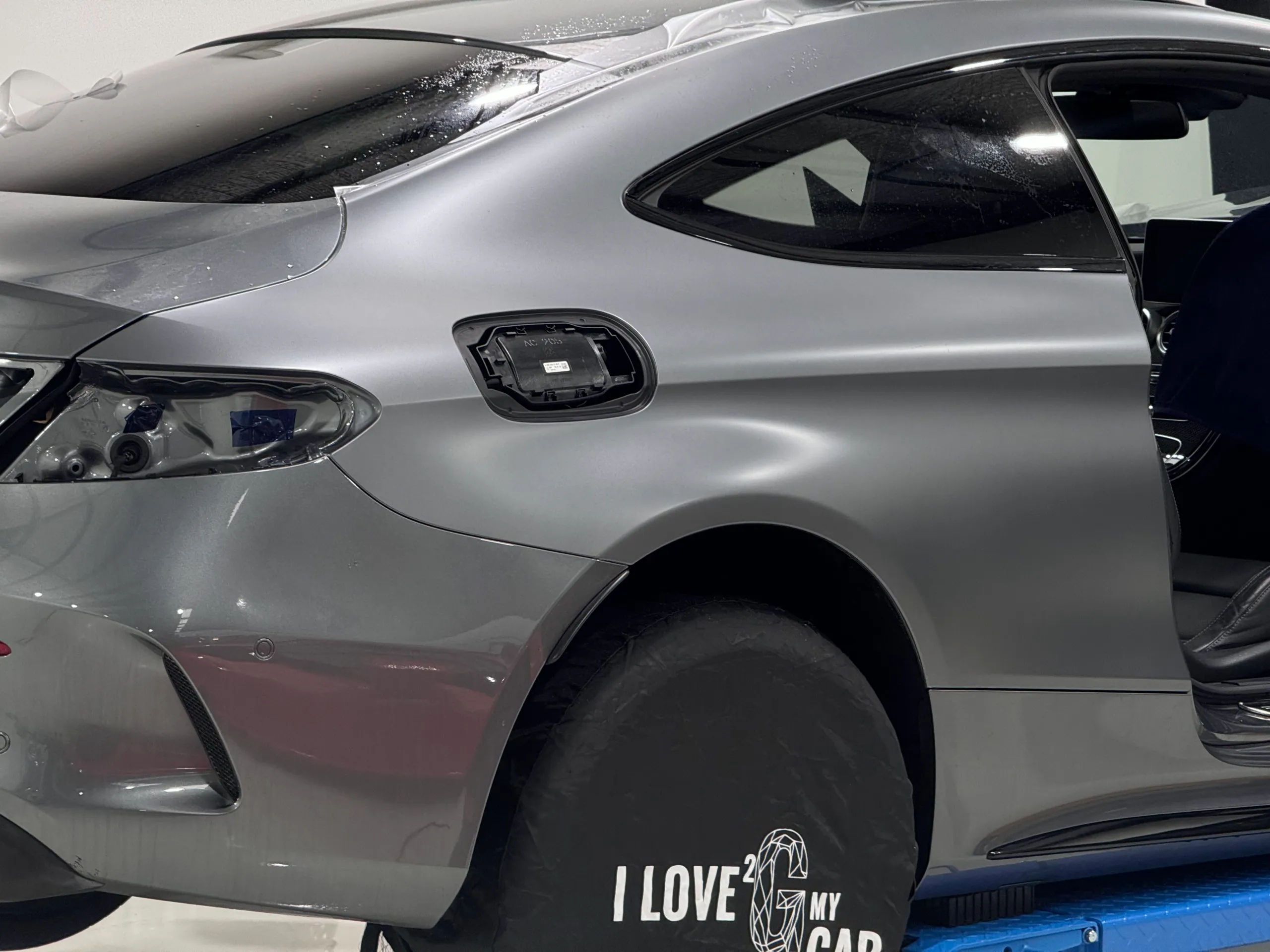 Satin grey Mercedes-AMG C63 S rear quarter with fuel flap and rear light removed during film installation