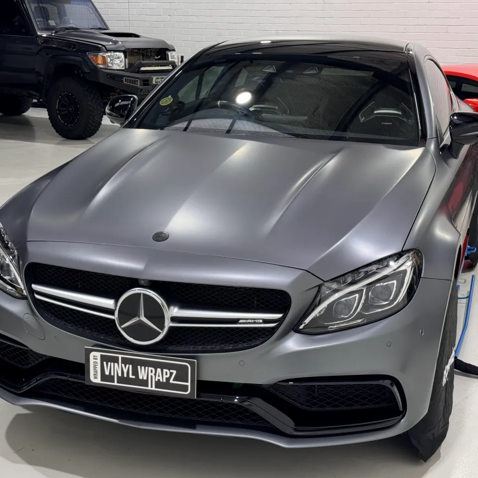 Satin grey Mercedes-AMG C63 S coupe viewed from the front quarter in the workshop