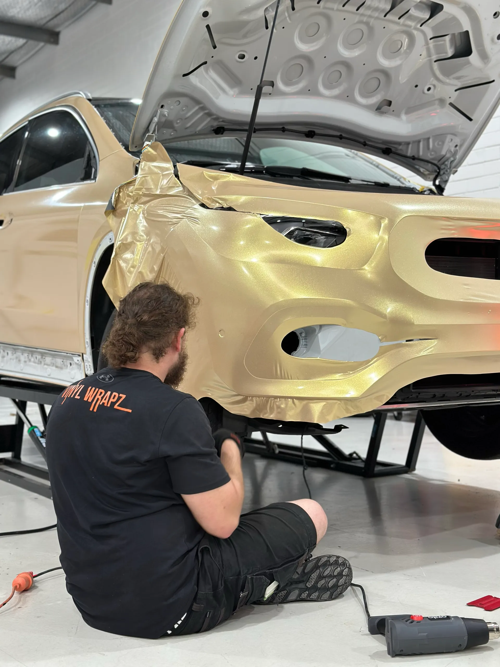 Installer finishing gold film around the Mercedes-Benz GLA lower front bumper