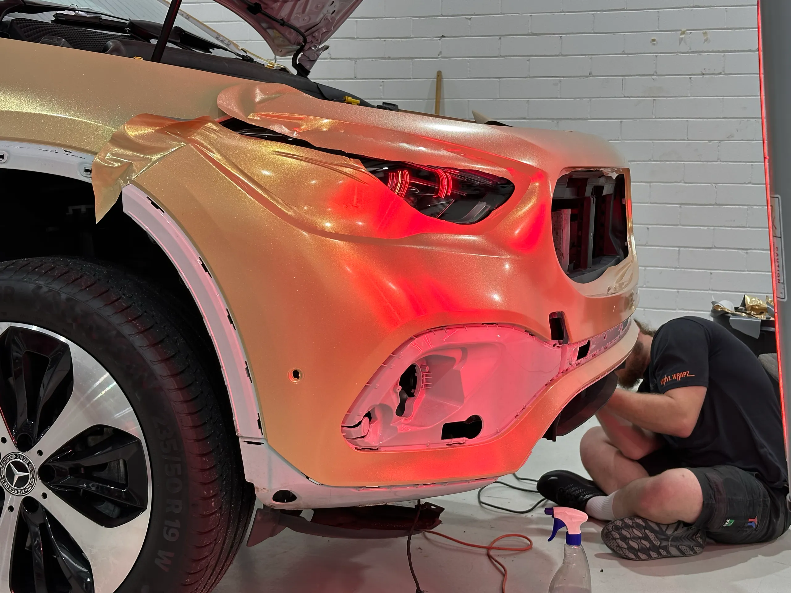 Gold film being fitted around the Mercedes-Benz GLA headlight and bumper openings