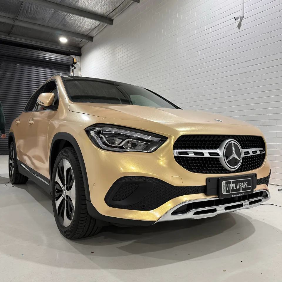 Gold shimmer Mercedes-Benz GLA viewed from the front quarter in the workshop