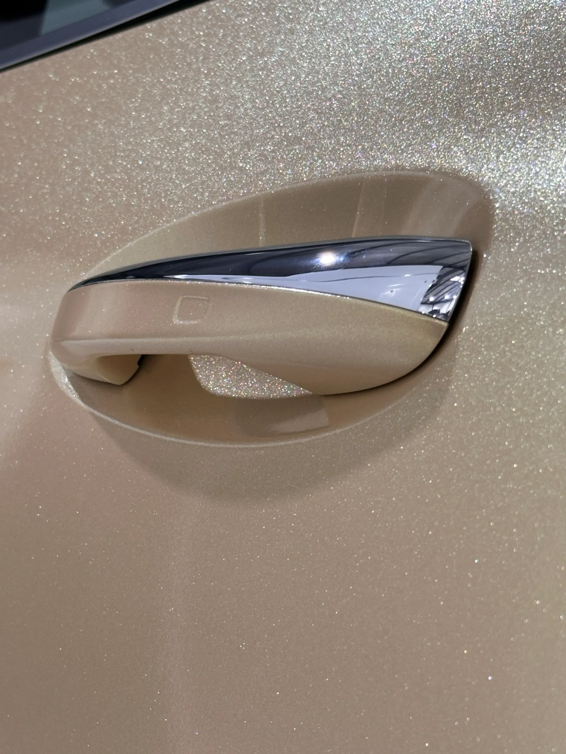Gold Mercedes-Benz GLA door handle with chrome trim and a shimmering finish