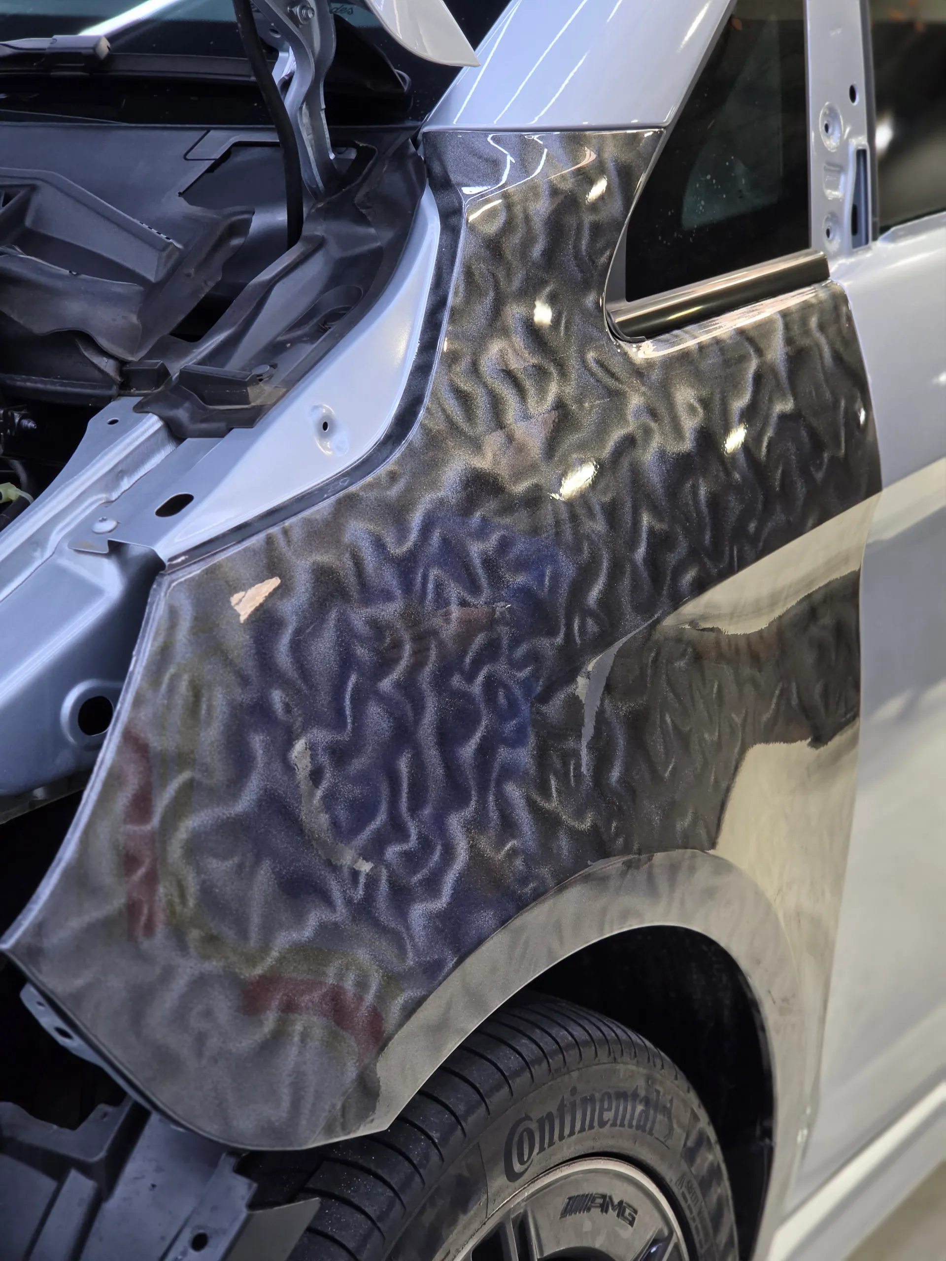 Patterned grey film on the Mercedes-Benz V-Class front guard during installation, with the bonnet open