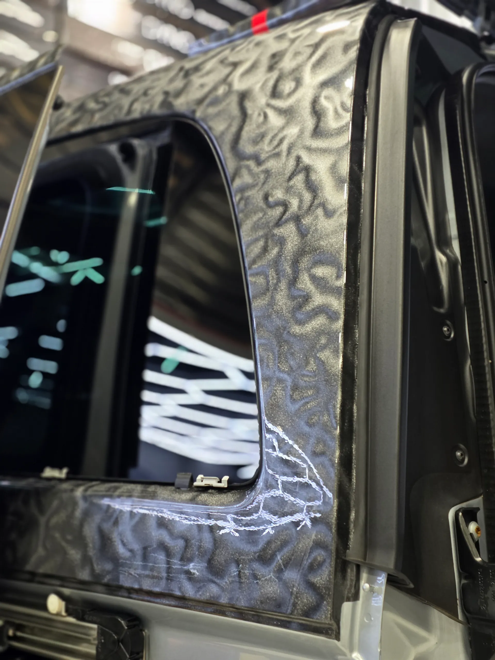 Patterned grey film around the Mercedes-Benz V-Class rear quarter window during installation