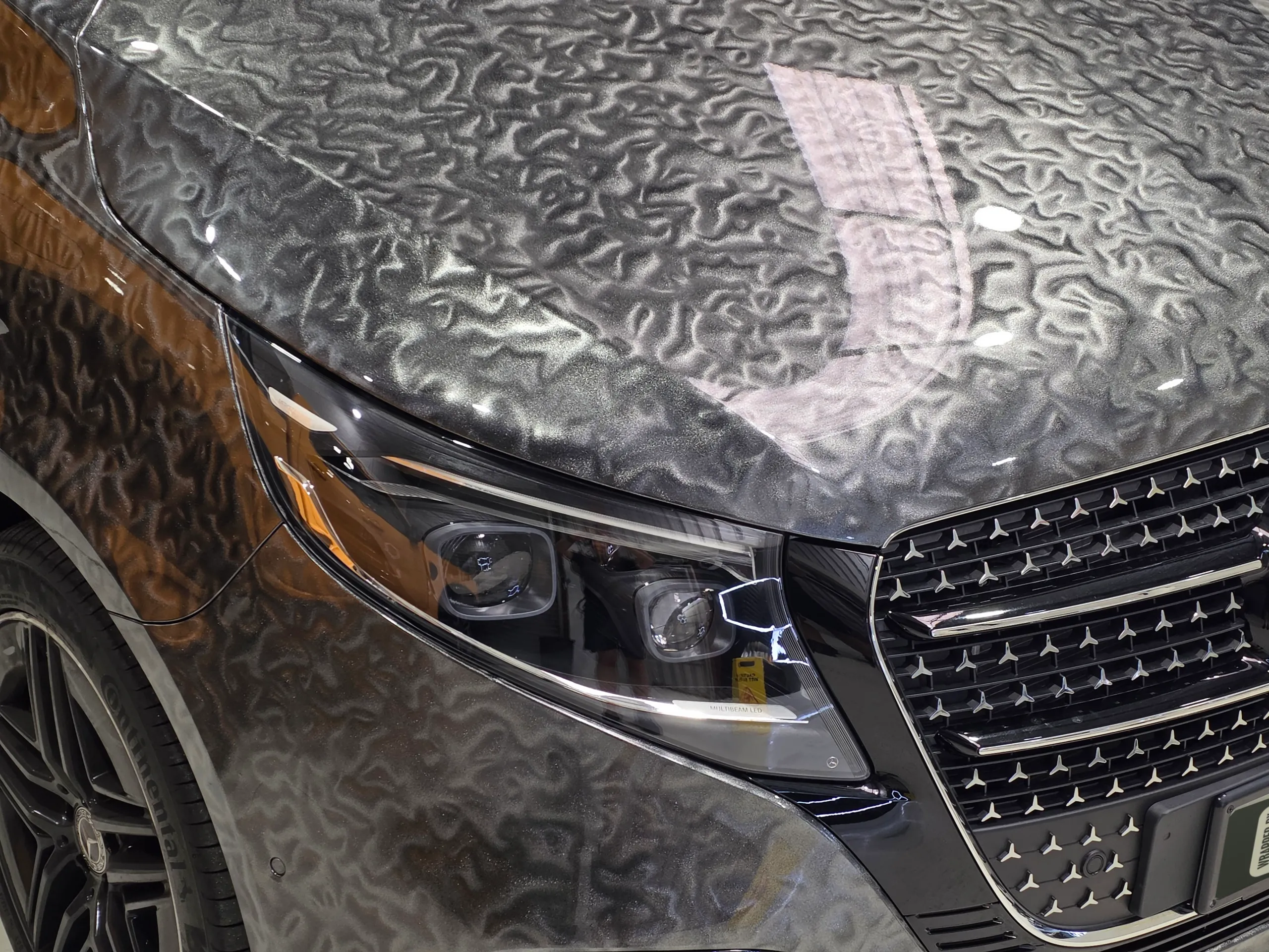 Gloss patterned grey film across the Mercedes-Benz V-Class bonnet above the headlight and grille