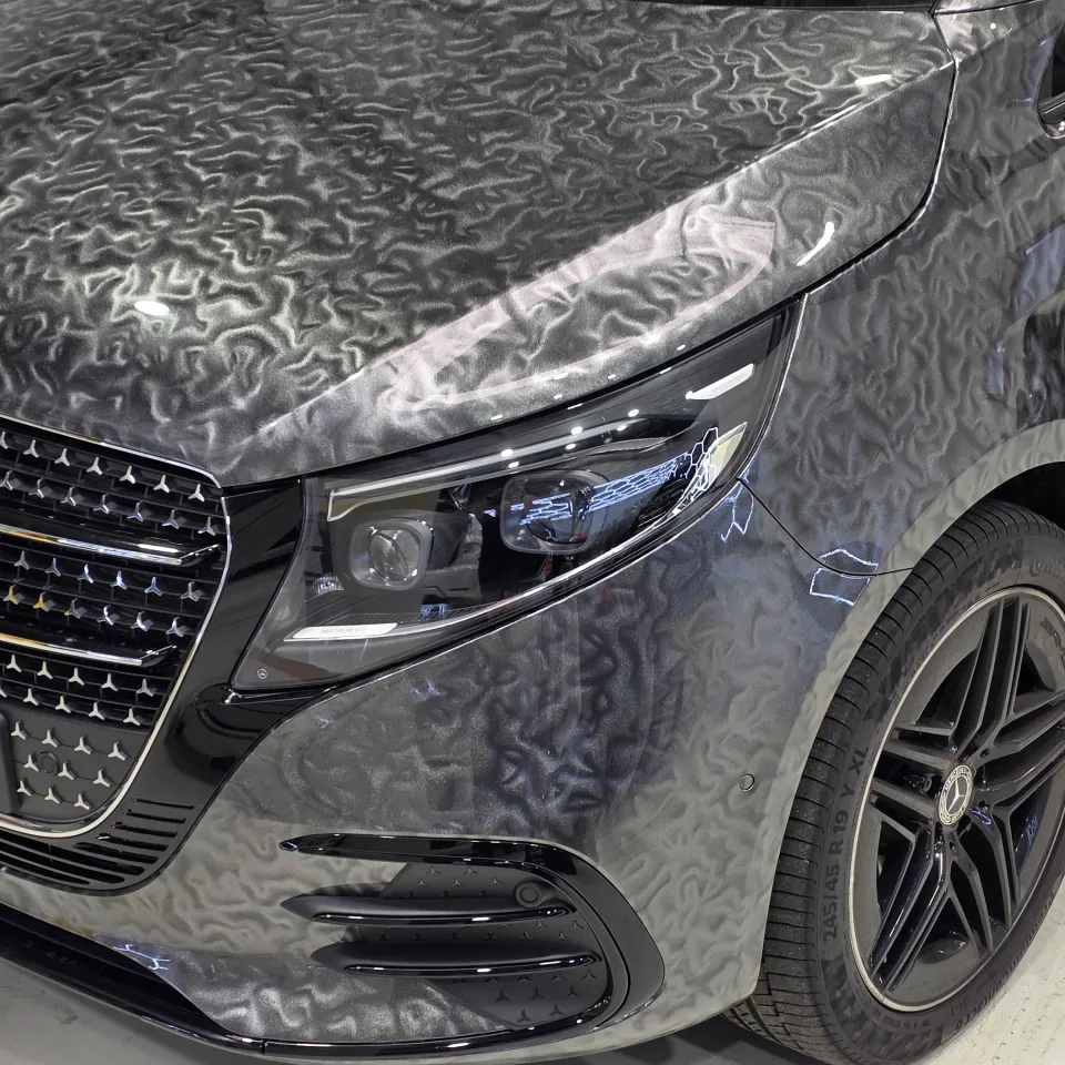 Mercedes-Benz V-Class front corner with patterned grey film and a black alloy wheel