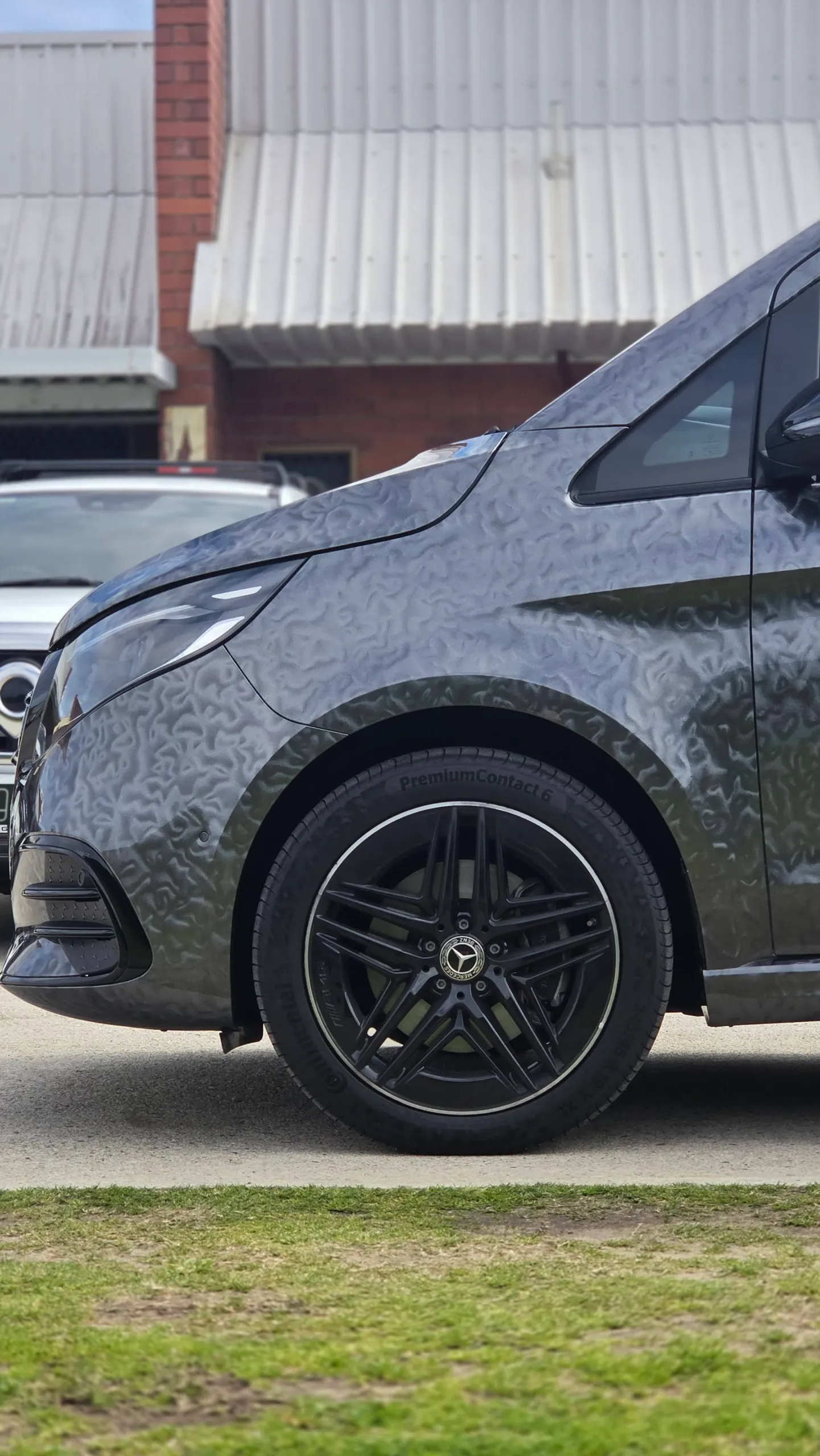 Patterned grey Mercedes-Benz V-Class front guard and black alloy wheel outdoors