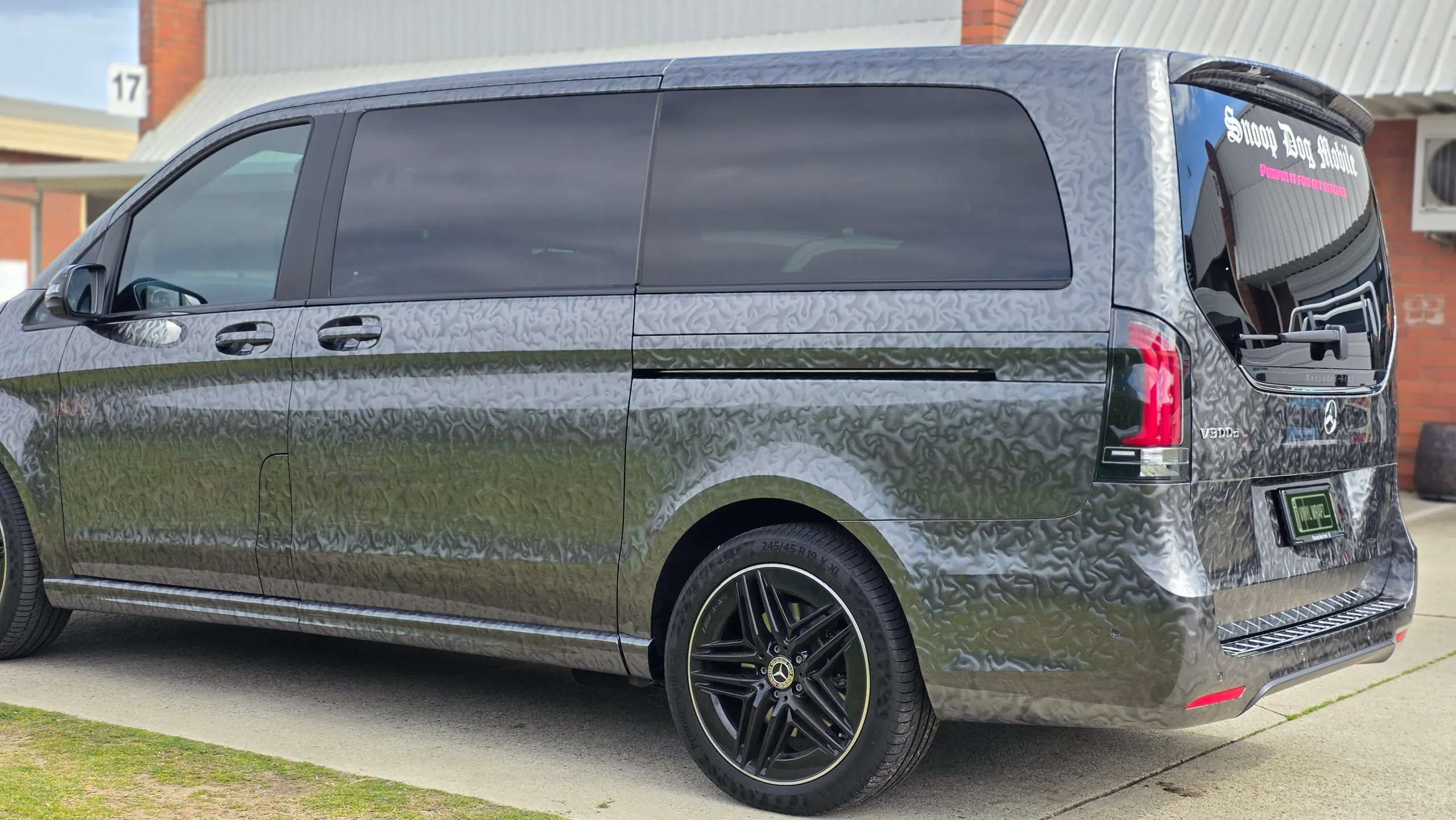 Side and rear of the patterned grey Mercedes-Benz V-Class outside the workshop