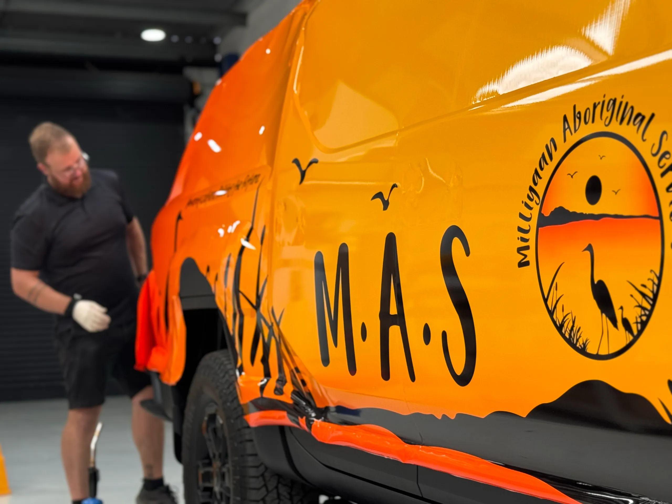 Milliyaan Aboriginal Services graphics being fitted to the Kia Tasman doors
