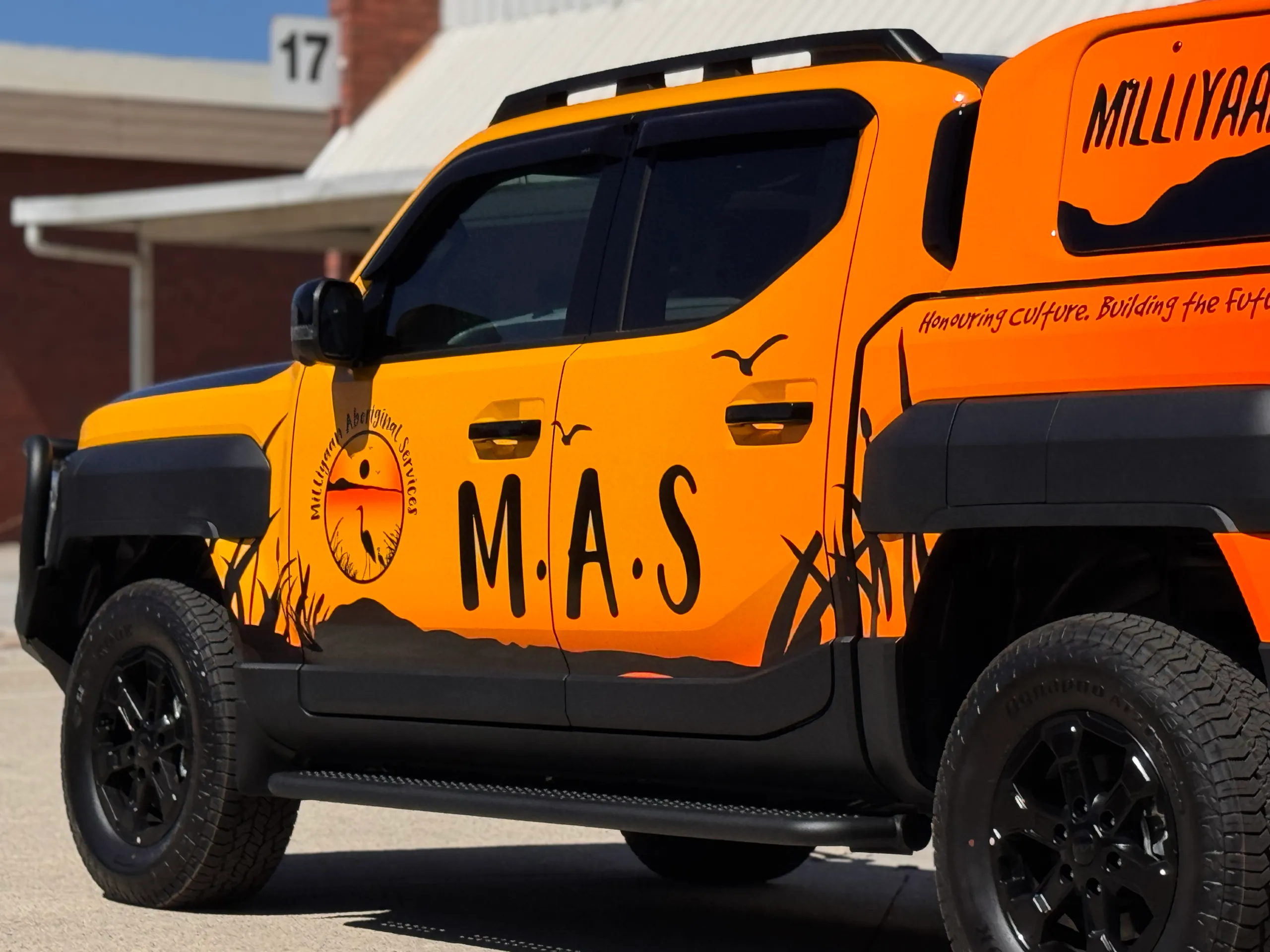 Milliyaan Aboriginal Services logo and M.A.S lettering across the yellow Kia Tasman doors