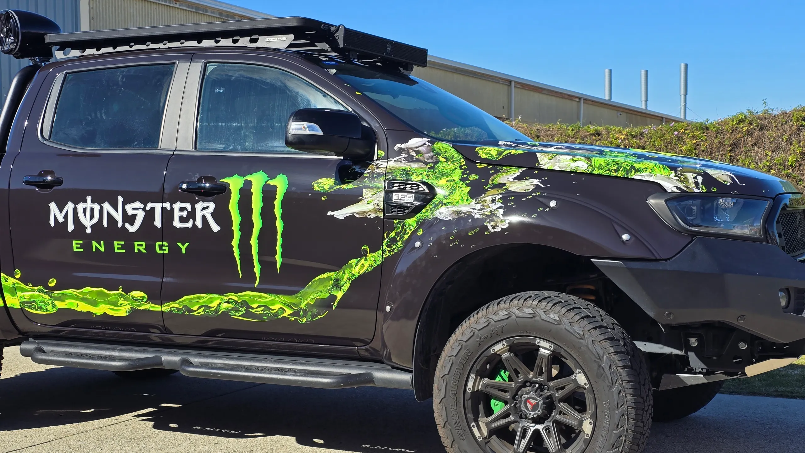 Monster Energy graphics across the Ford Ranger cab and front guard beneath a roof rack