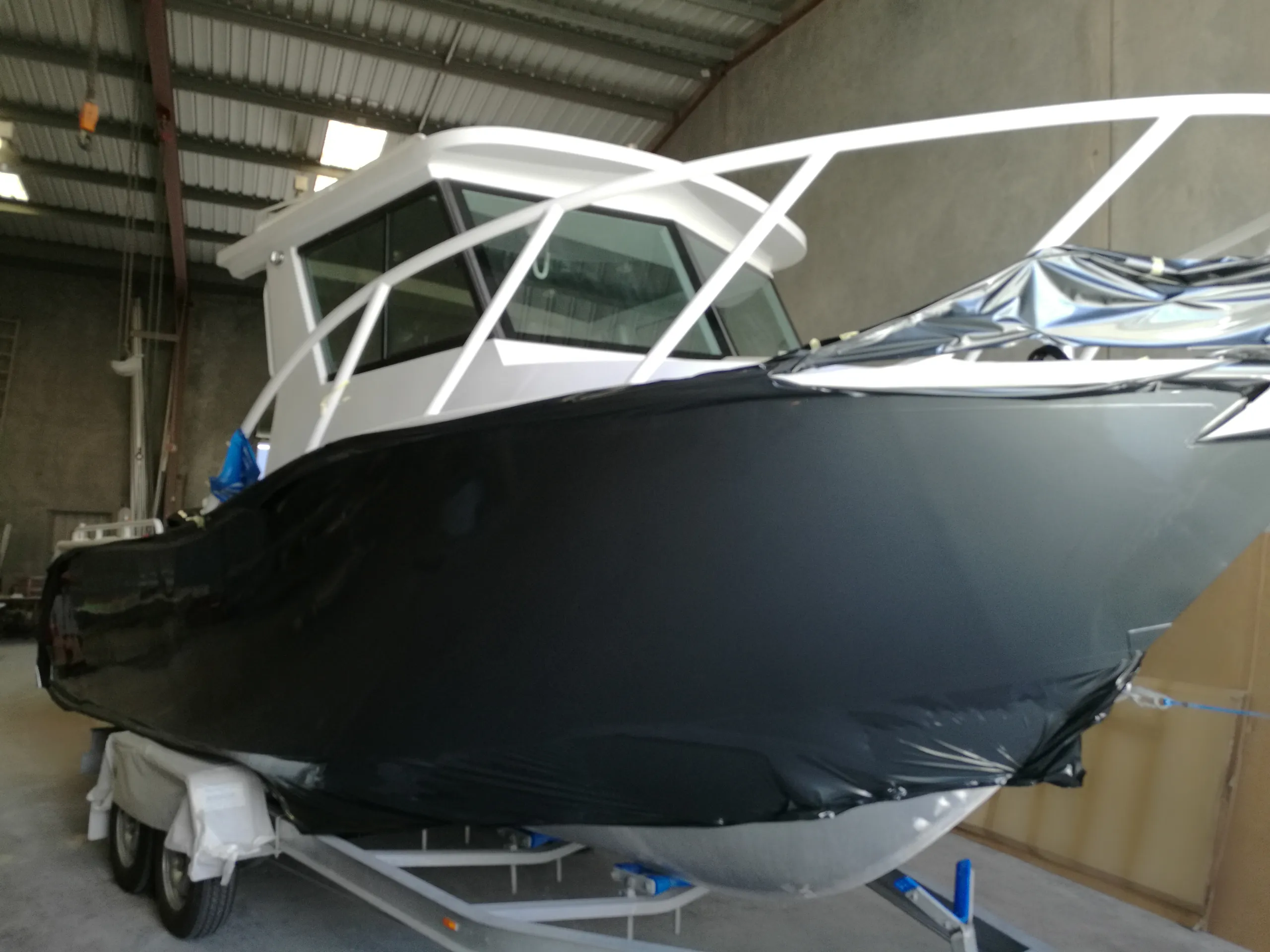 Loose charcoal film fitted along the boat hull during a colour change in the workshop