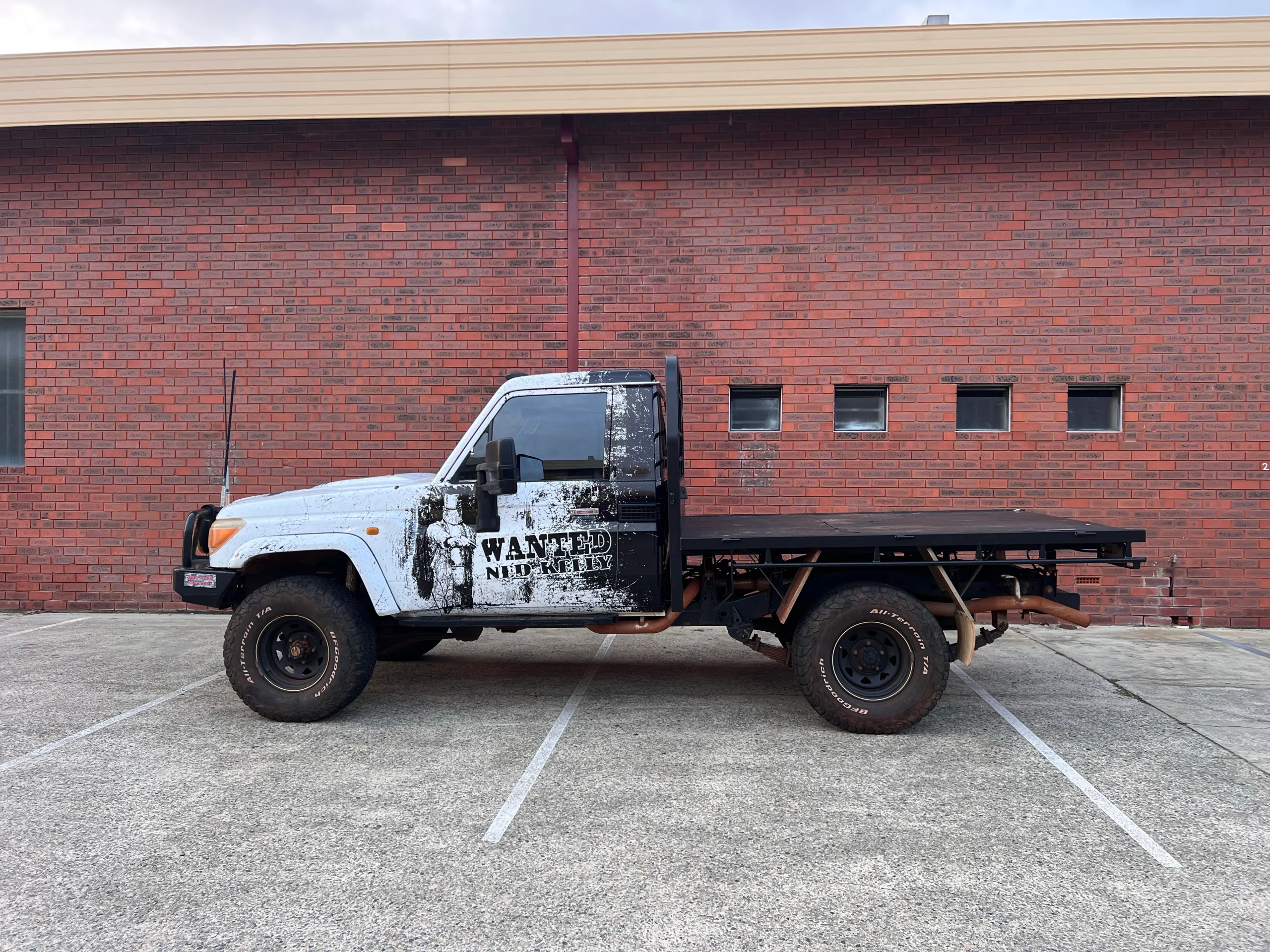 Completed black Ned Kelly LandCruiser cab with tray outside