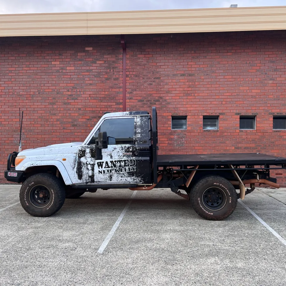 Completed black Ned Kelly LandCruiser cab with tray outside