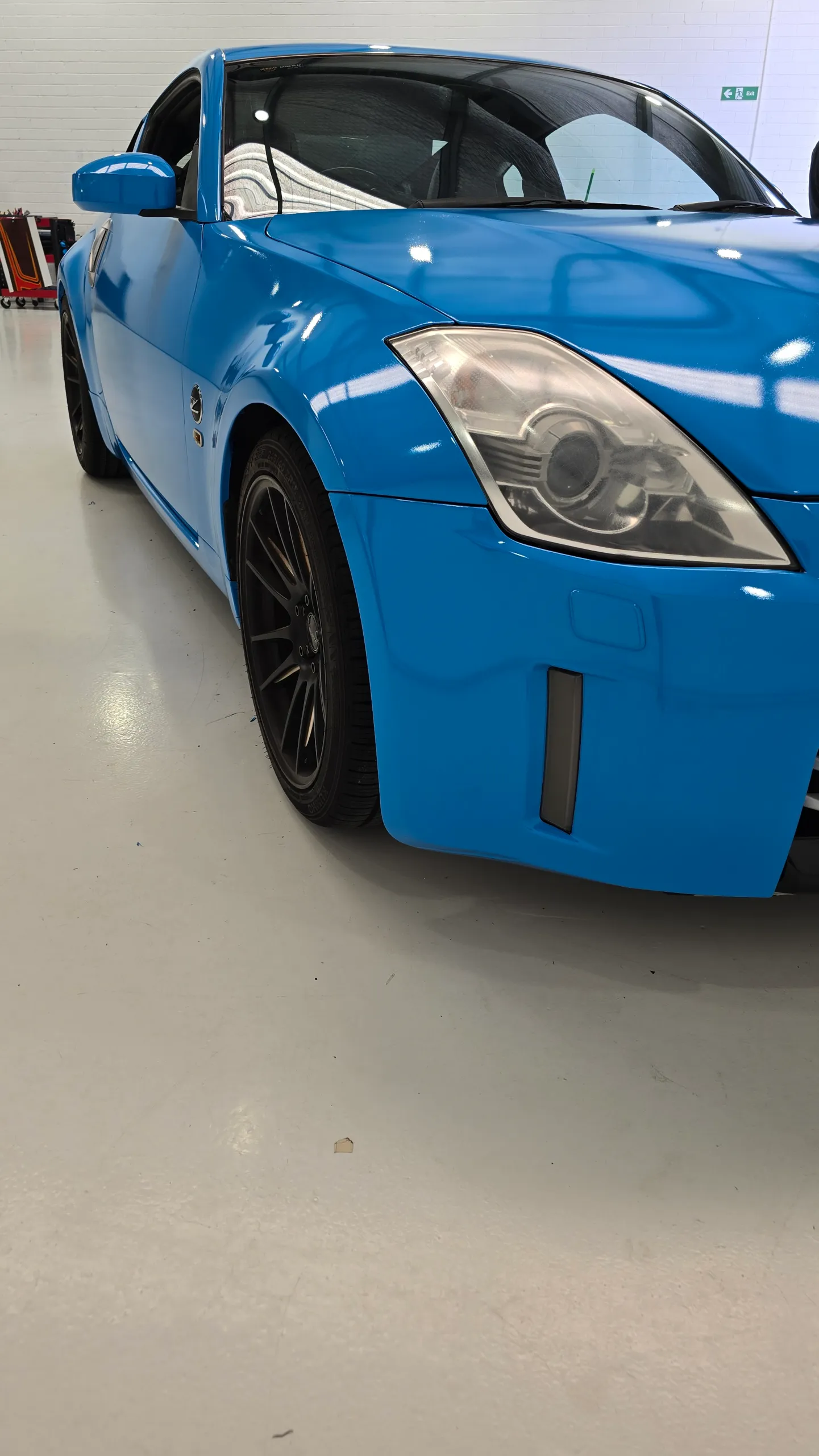 Gloss light blue Nissan 350Z in the workshop, front detail