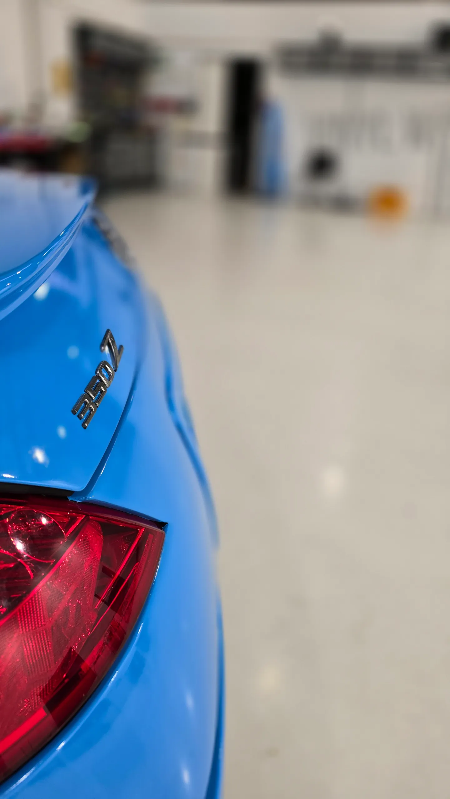 Gloss light blue Nissan 350Z in the workshop, rear badge detail