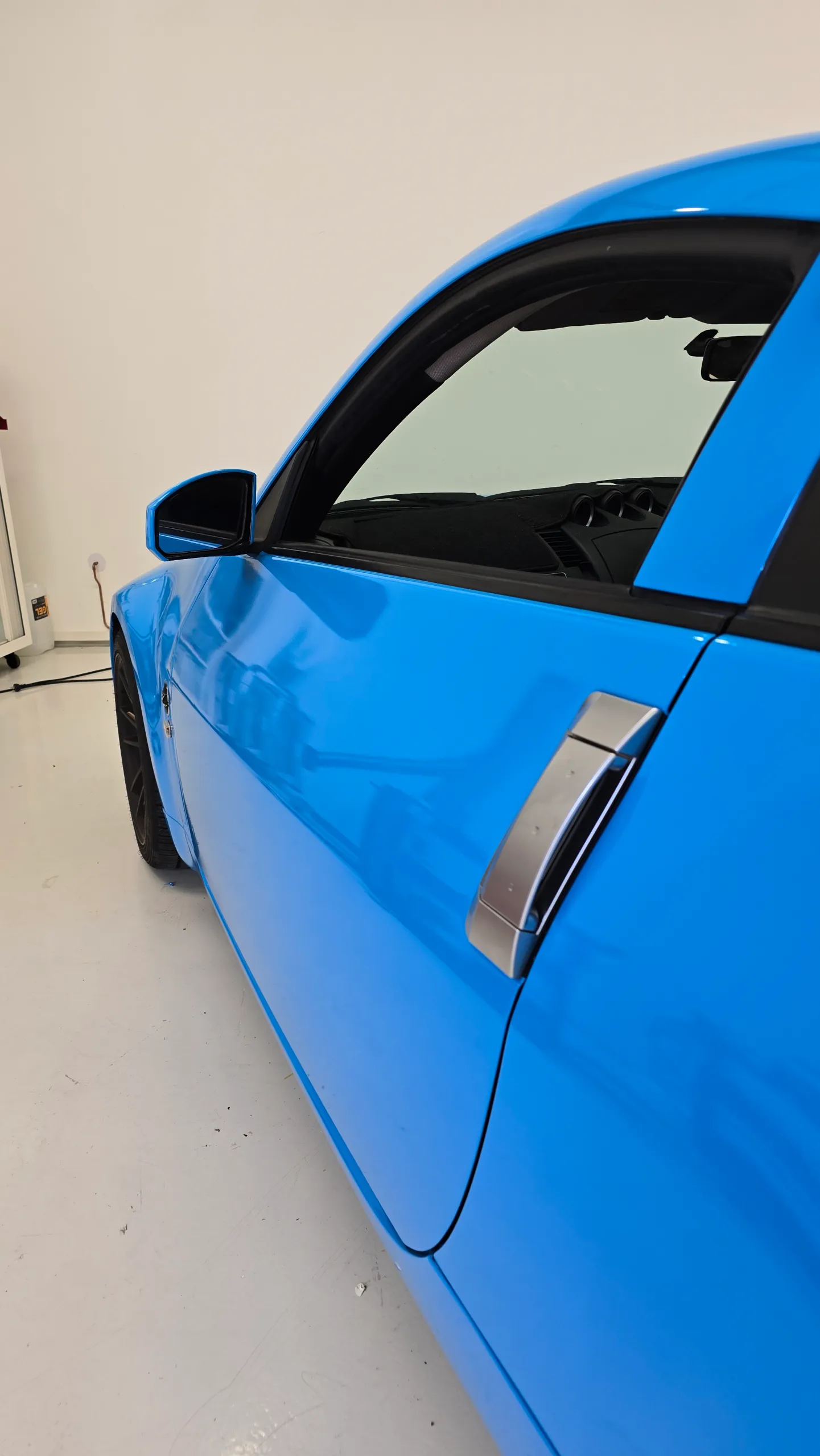 Gloss light blue Nissan 350Z in the workshop, door detail