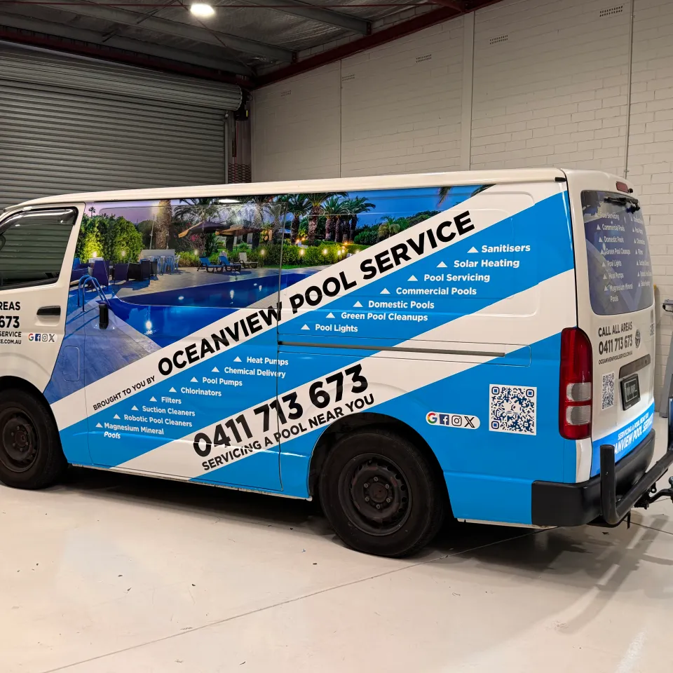 Oceanview Pool Service Toyota HiAce with blue and white graphics and a printed pool image in the workshop