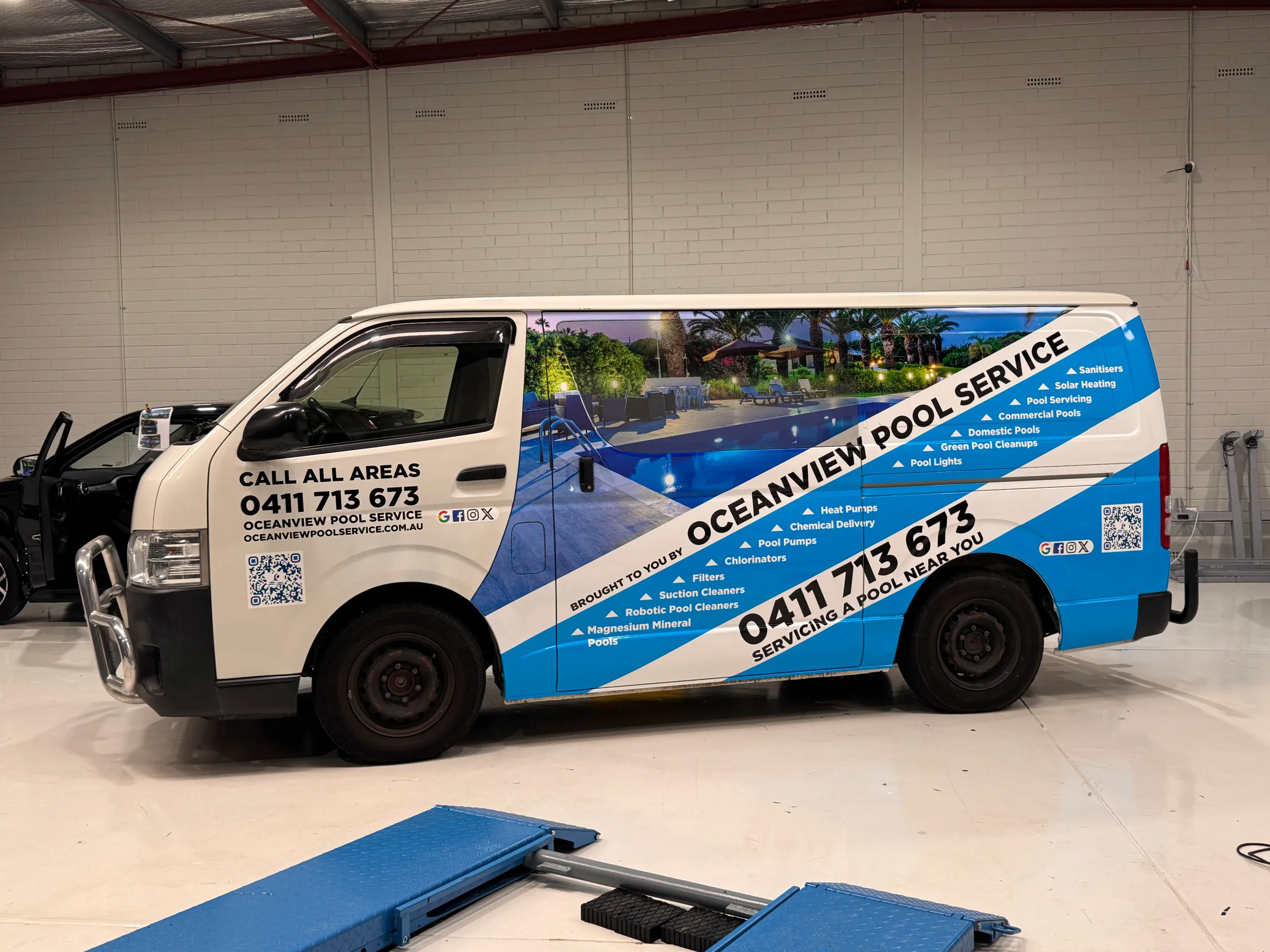 Side view of the Oceanview Pool Service Toyota HiAce showing its pool photograph and blue diagonal graphics