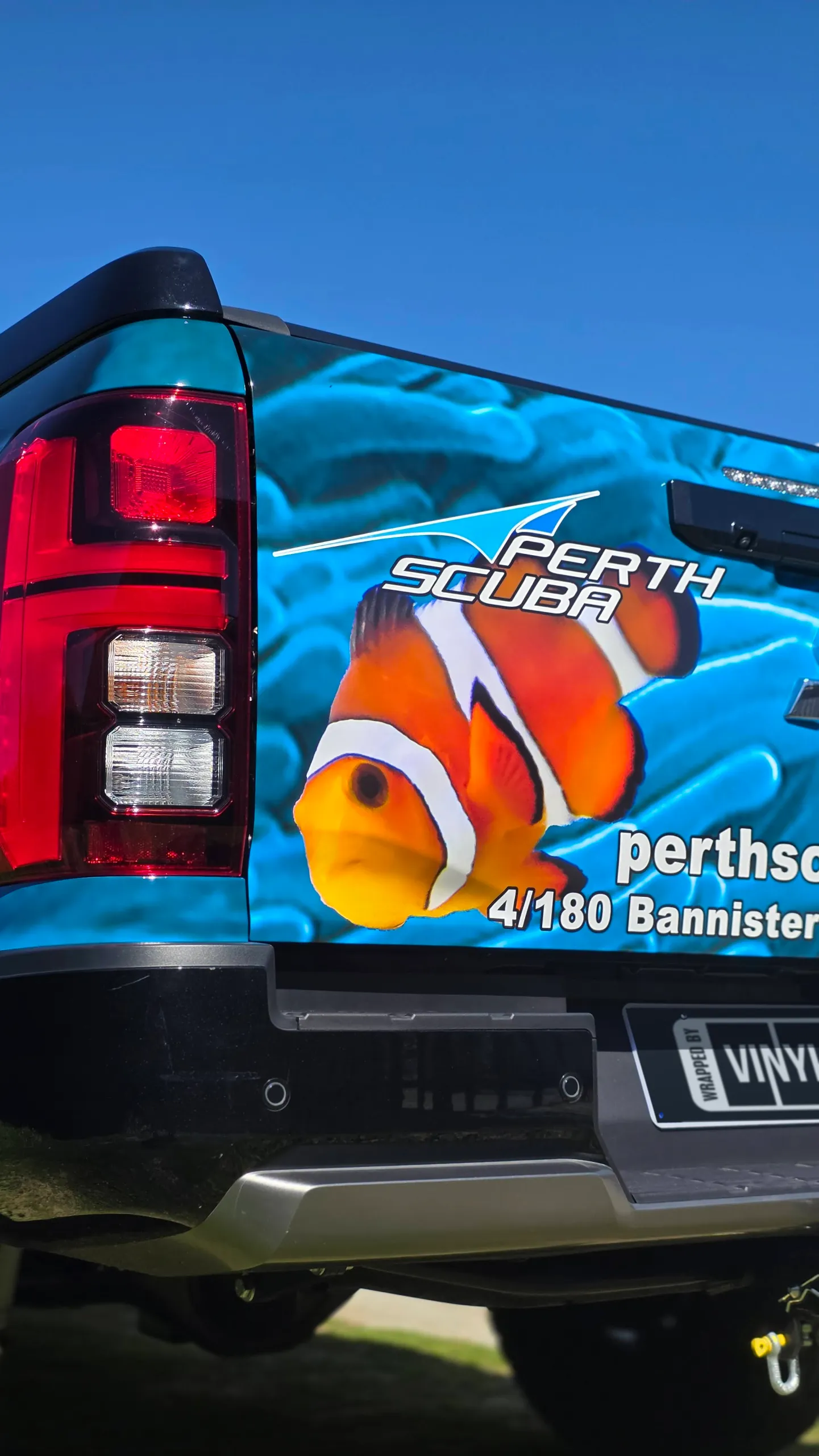 Perth Scuba clownfish graphics on the Mitsubishi Triton tailgate beside its rear light