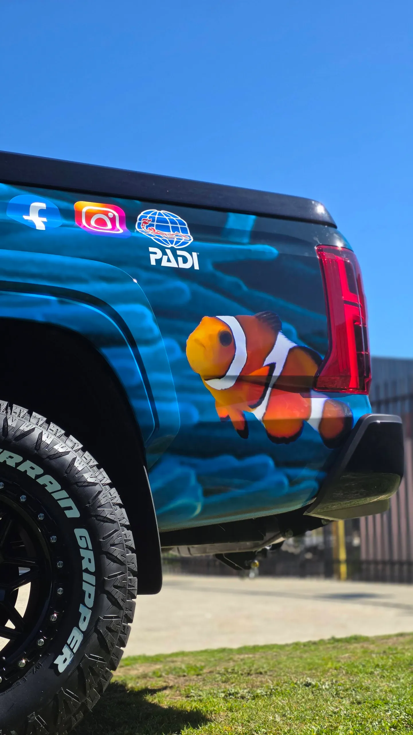 Clownfish and blue water graphics on the Triton rear quarter above its black wheel
