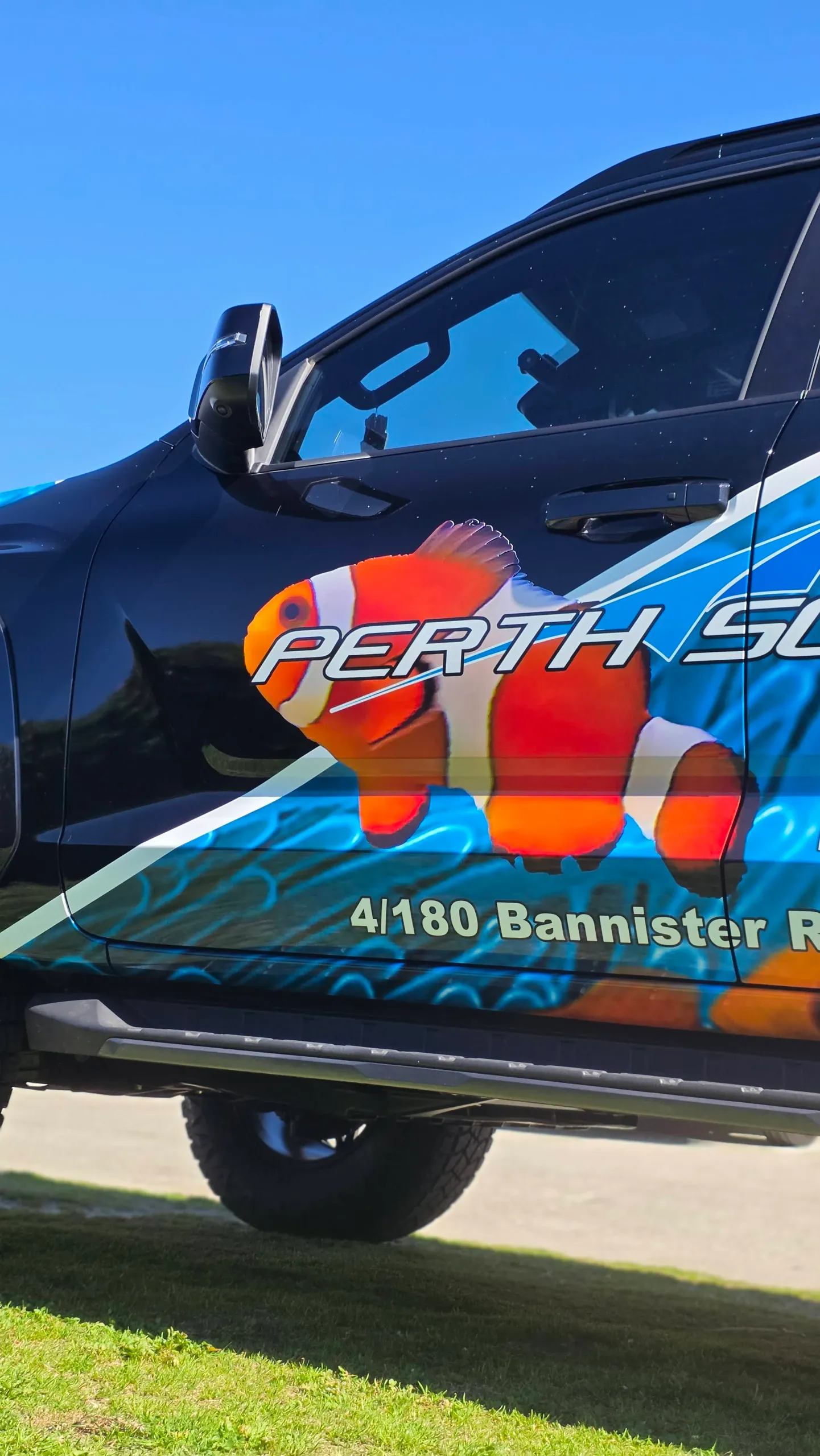 Close view of Perth Scuba lettering and clownfish artwork on the Triton front door