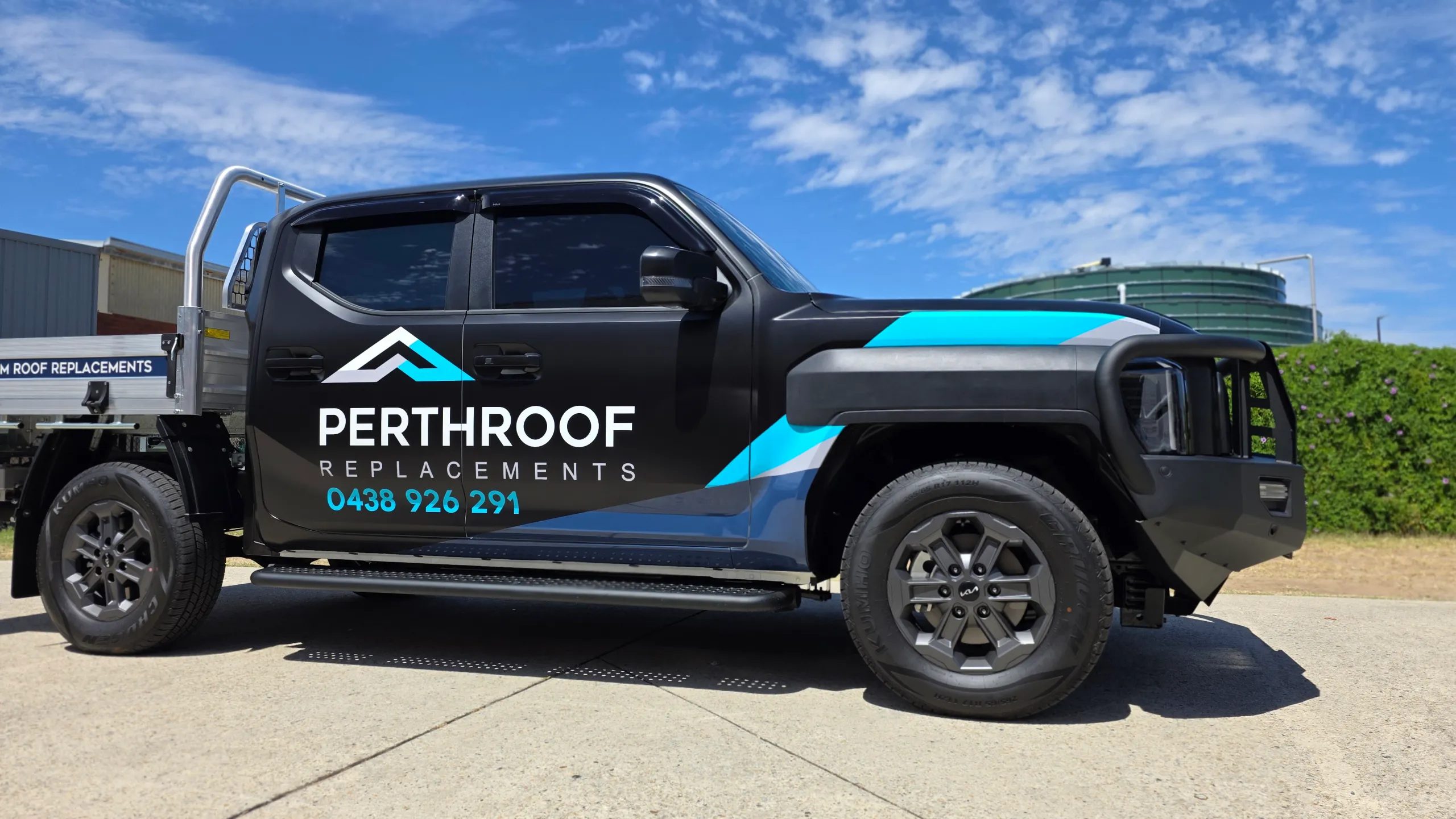 Side view of the black Kia Tasman cab with PerthRoof Replacements branding