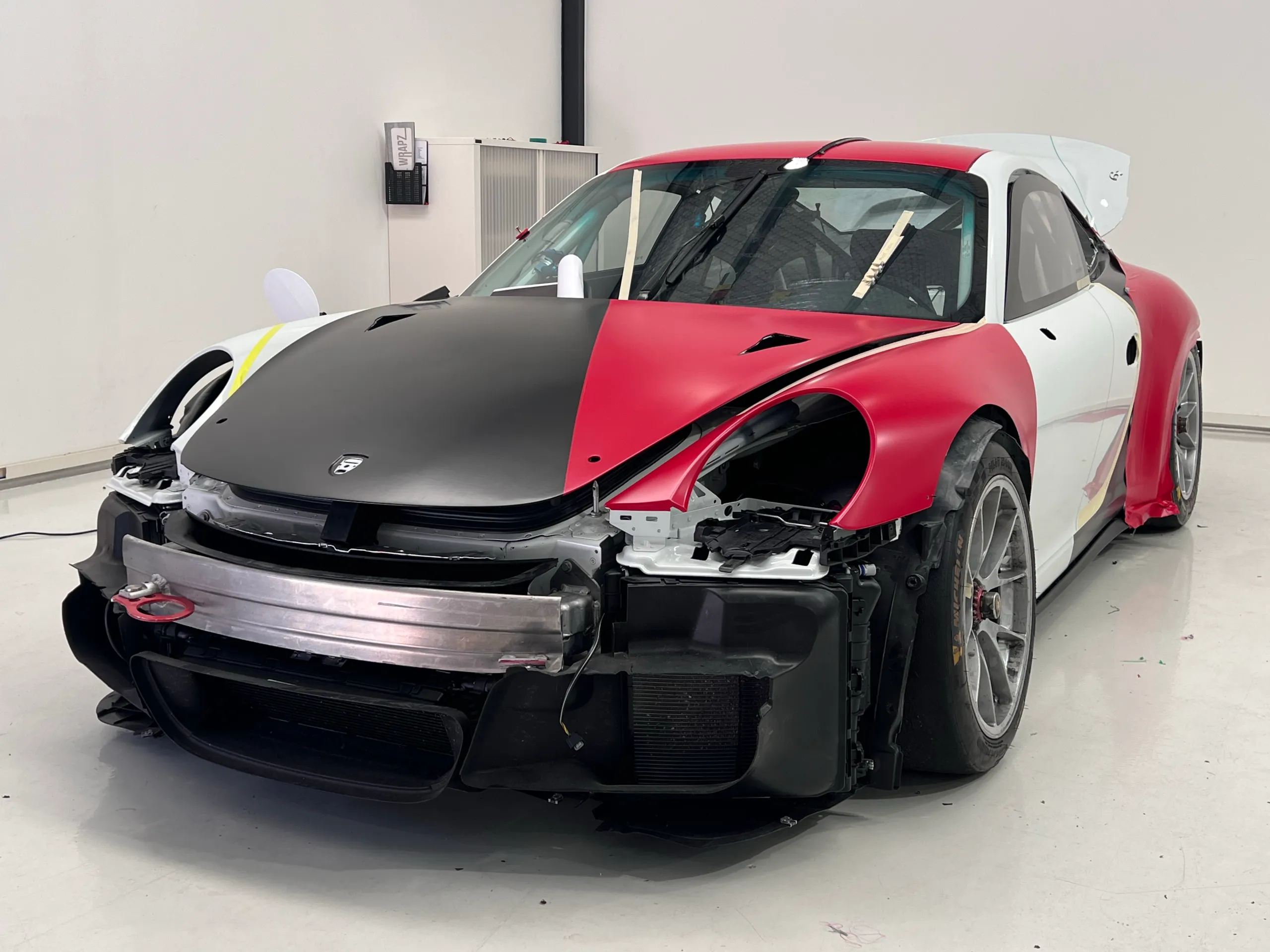 Porsche with the front bumper removed in the workshop