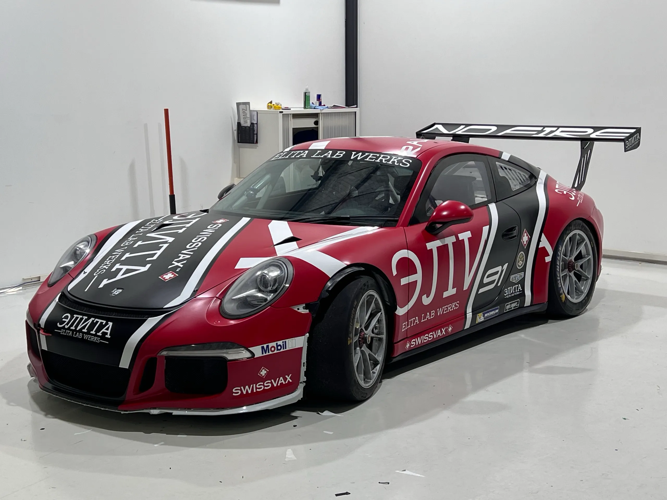 Completed red, white and black Porsche race livery in the workshop