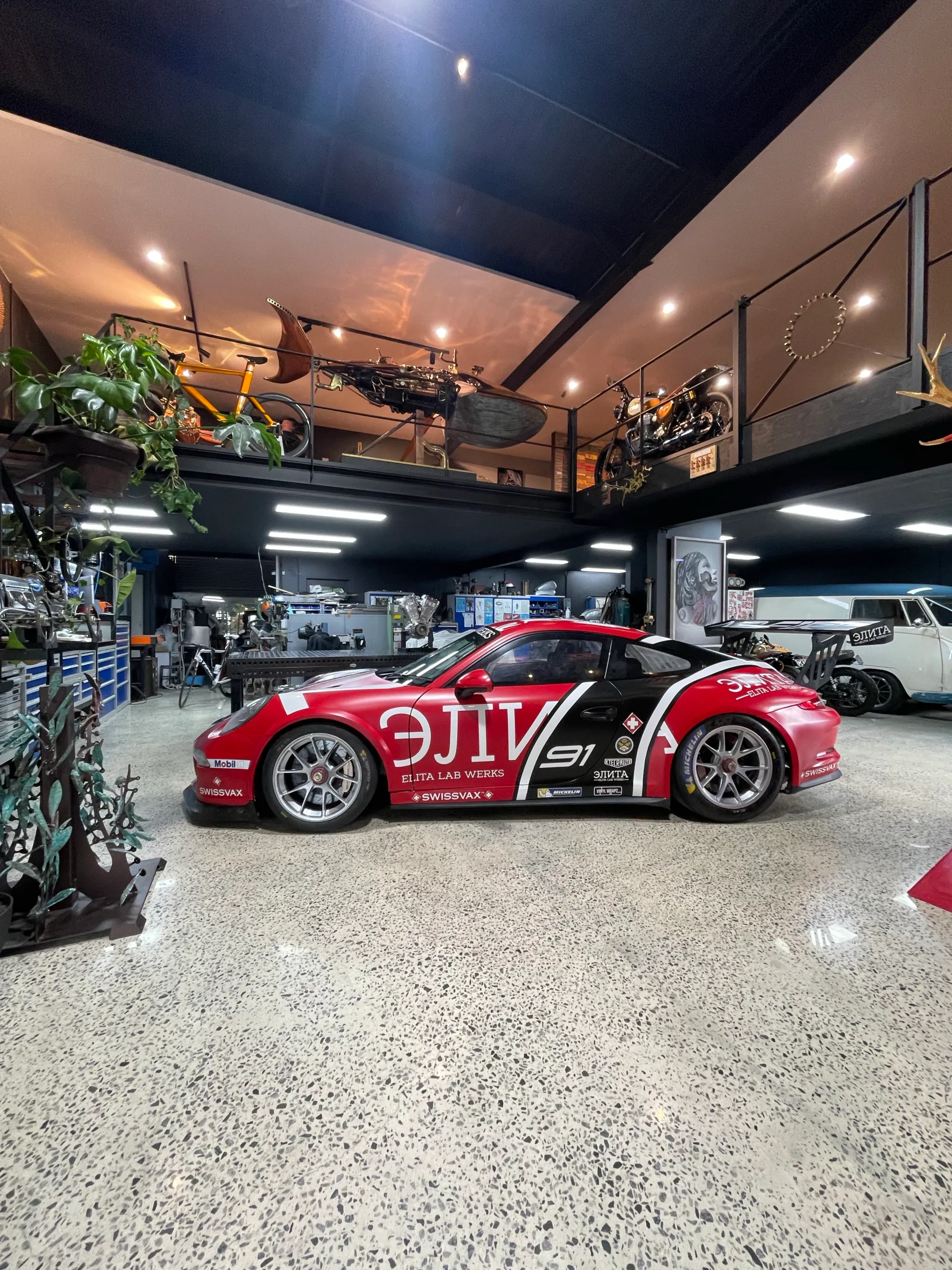 Wide side view of the Porsche race livery in the showroom