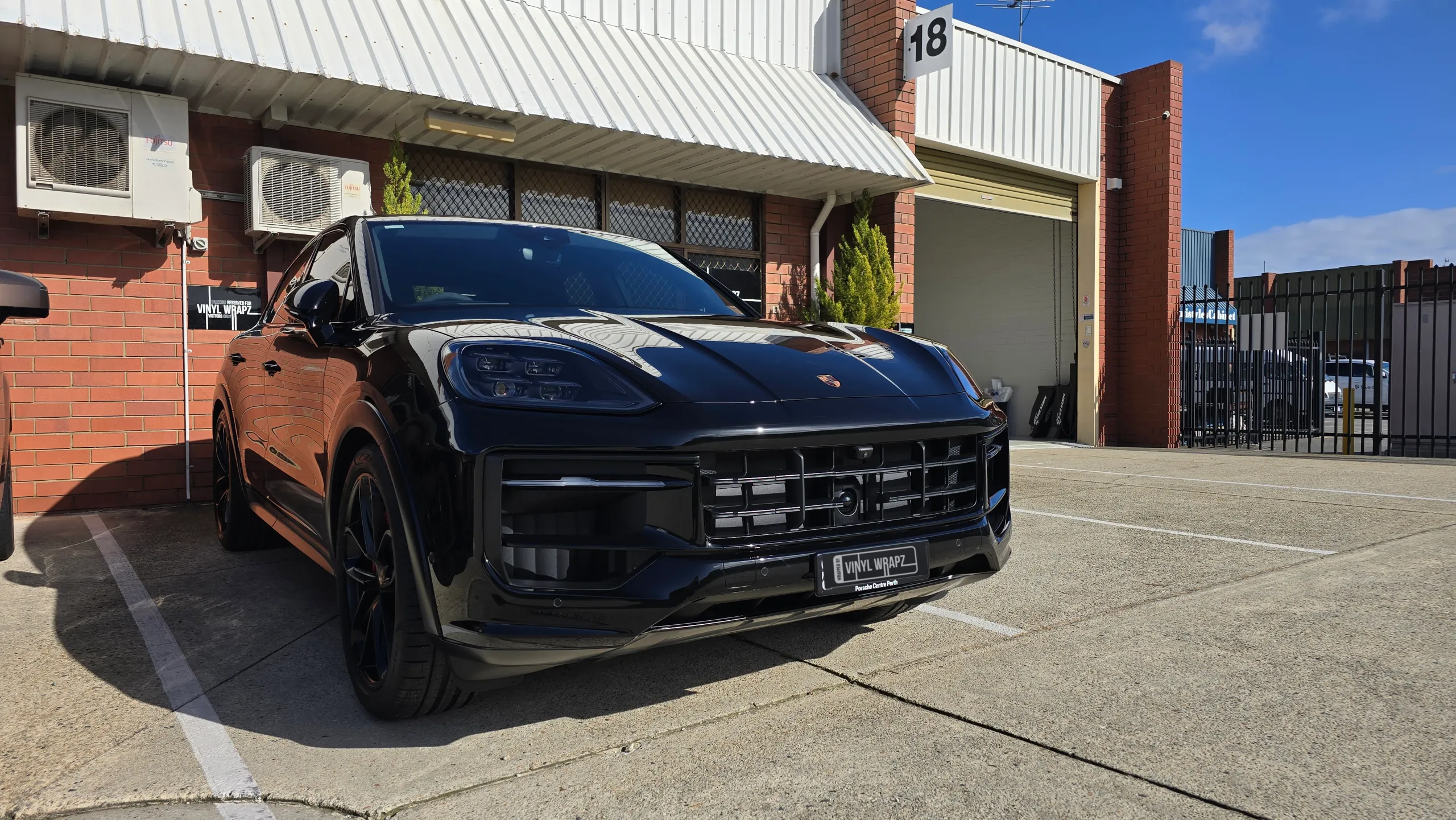 Gloss black Porsche Cayenne GTS parked outside the workshop