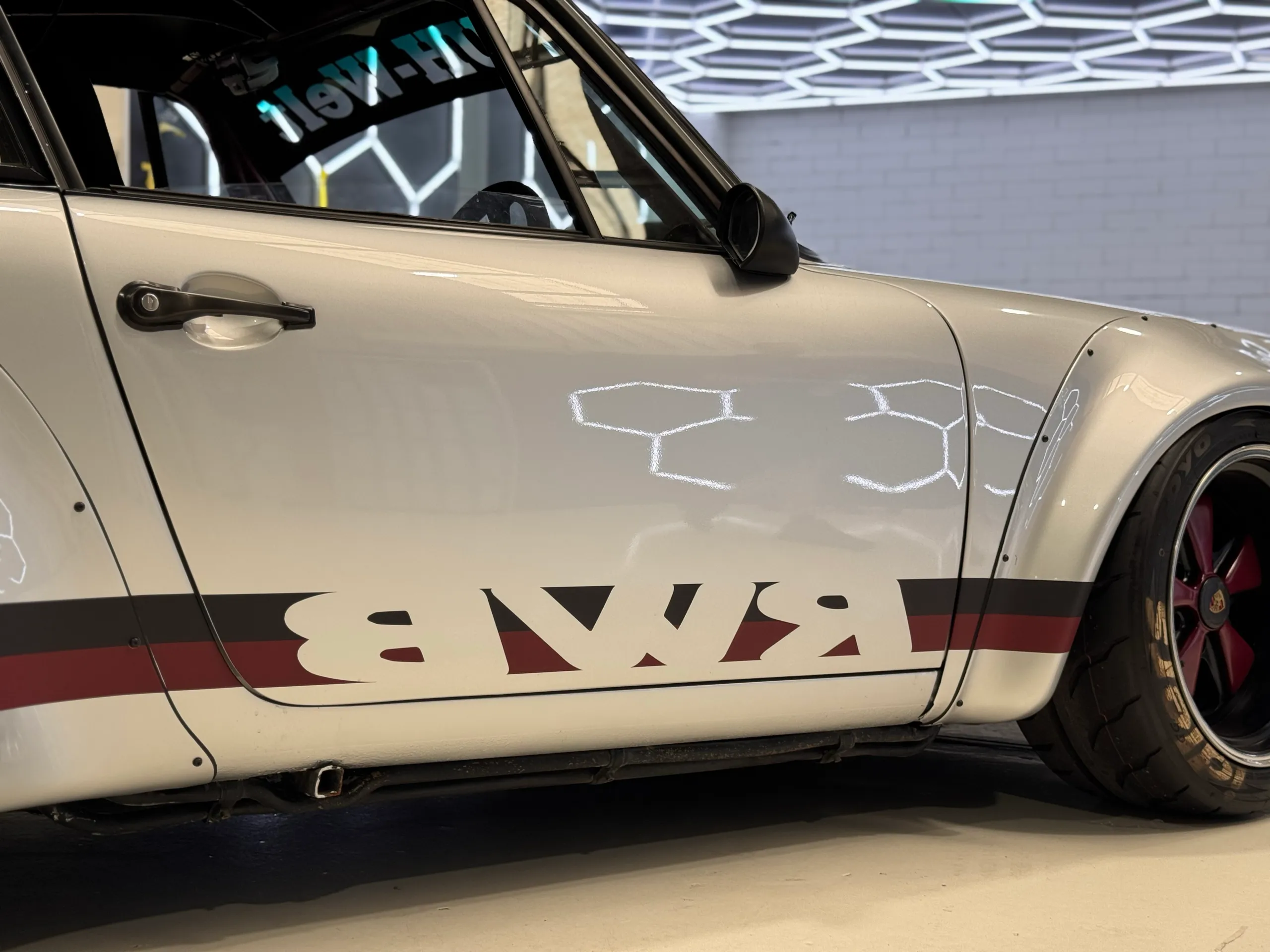 White Porsche door and wide front guard with black and red RWB side graphics