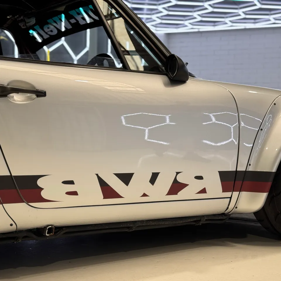 White Porsche door and wide front guard with black and red RWB side graphics