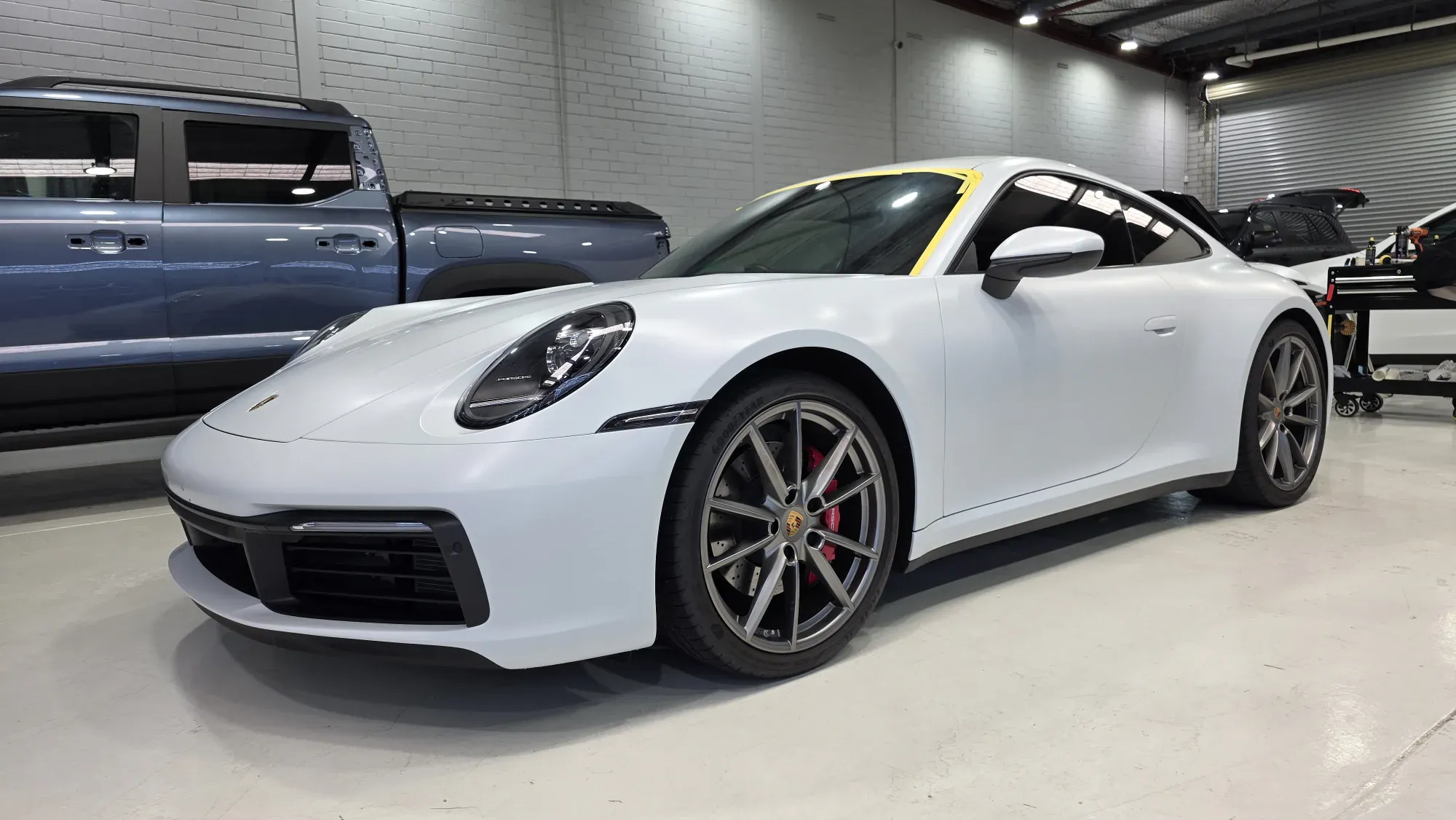 Porsche 911 Carrera S in satin paint protection film on the Vinyl Wrapz workshop floor