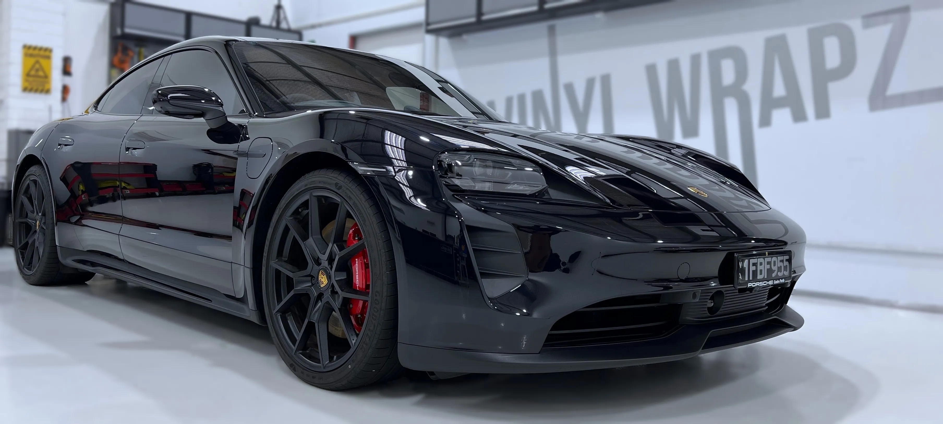 Black Porsche Taycan with clear paint protection film inside the Vinyl Wrapz workshop, Osborne Park