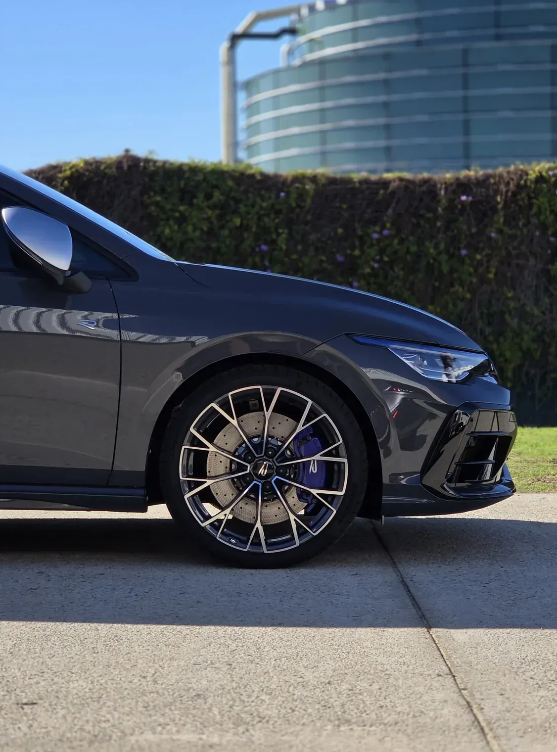 Front guard and wheel of a grey Volkswagen Golf R under gloss paint protection film