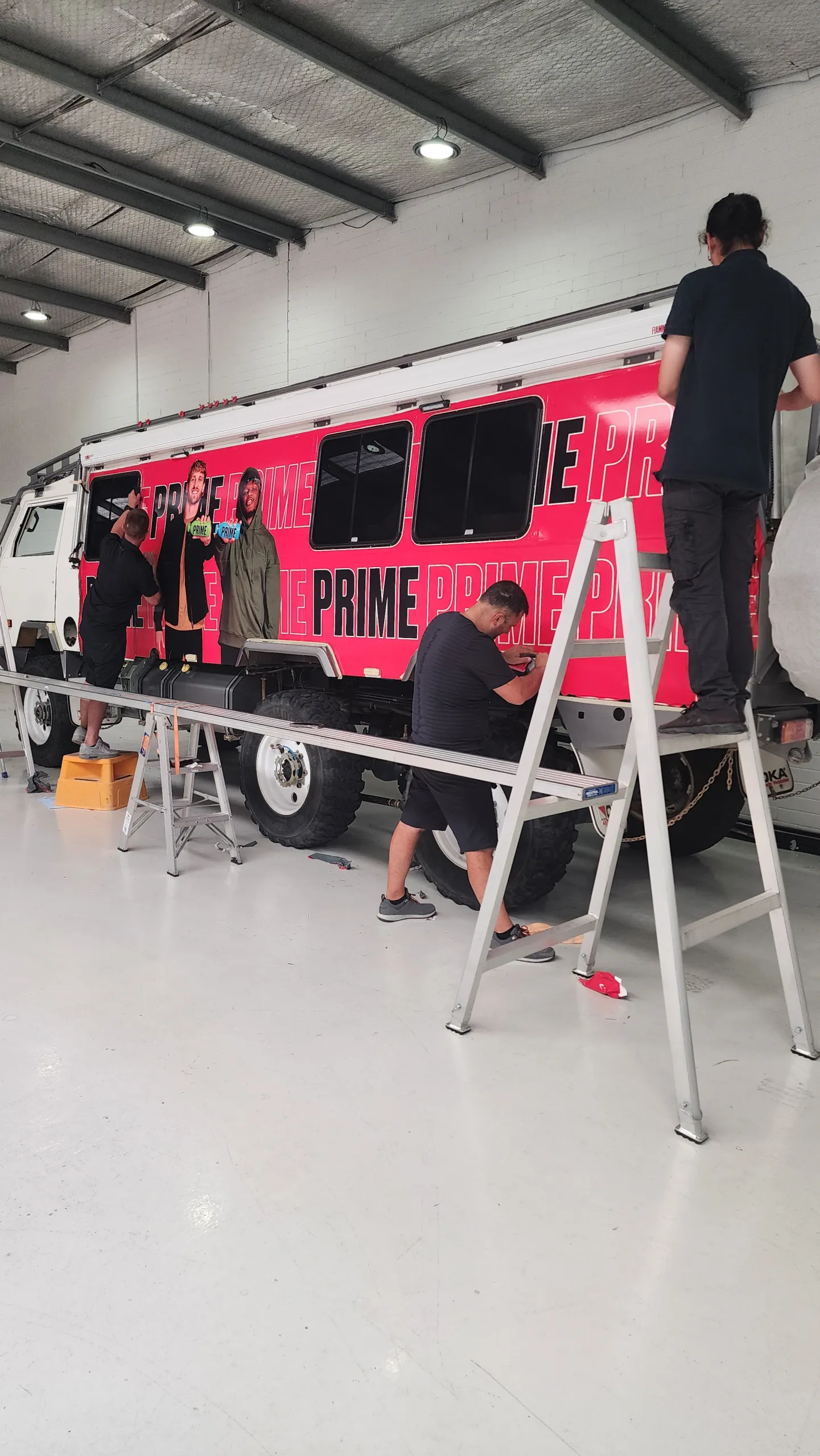 Installers applying printed film to the Oka side panels