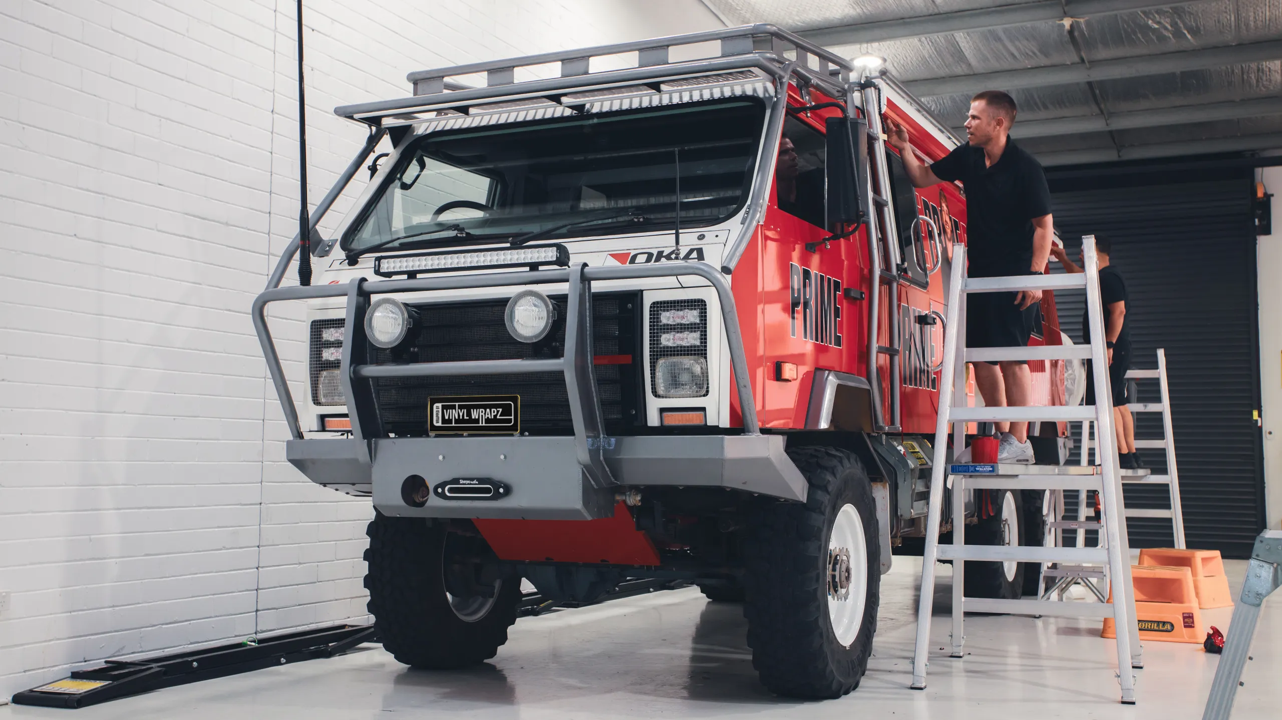 Installer fitting graphics above the Oka cab door