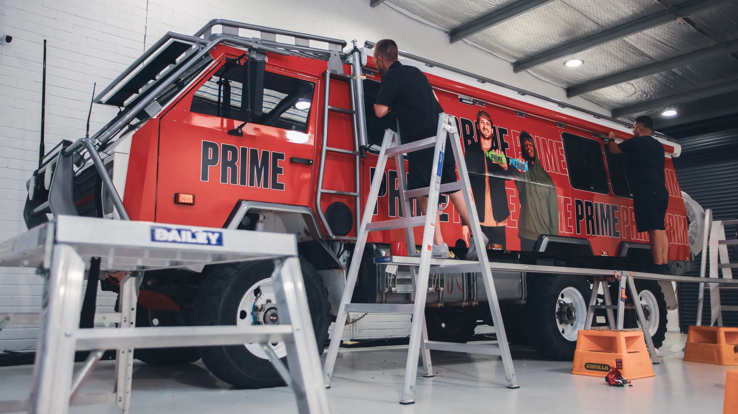 Installers fitting the upper edges of the Oka printed wrap