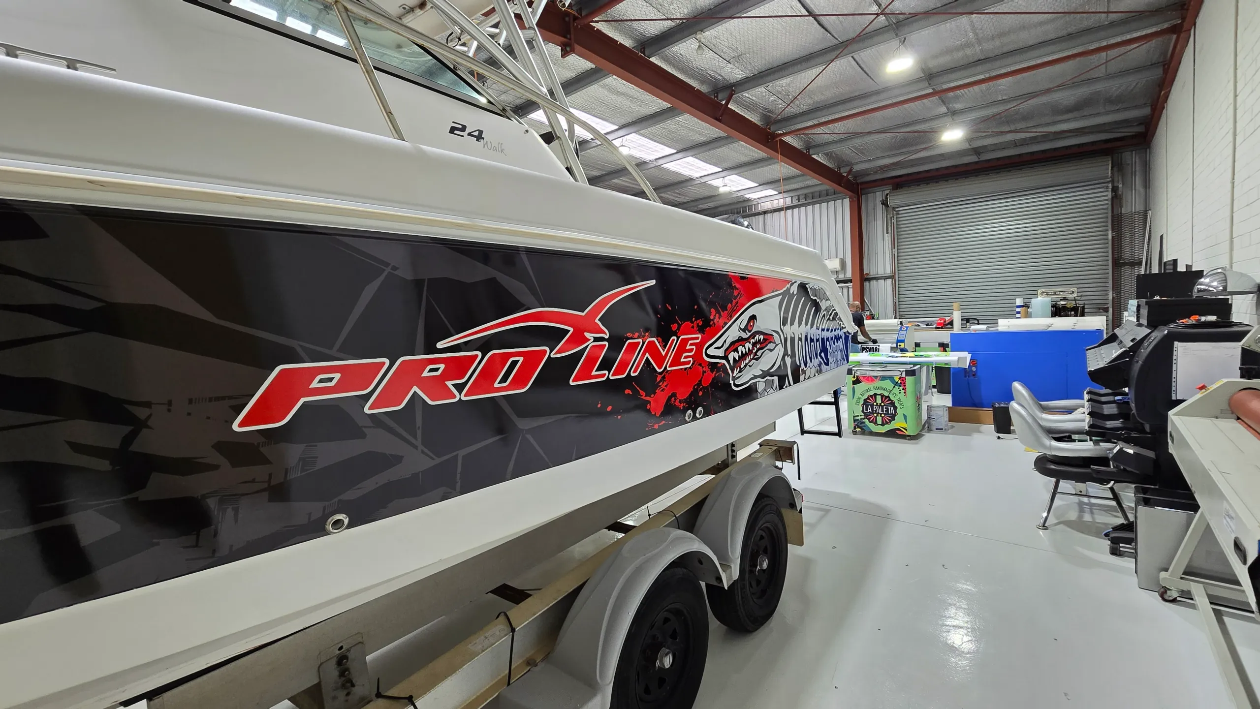 Red Pro-Line lettering beside shark artwork on the black hull wrap