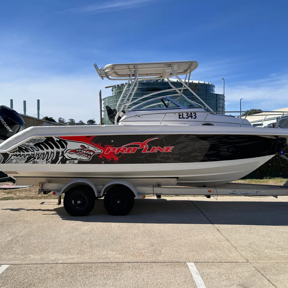 Pro-Line boat on a trailer with a black hull wrap, red lettering and white shark artwork