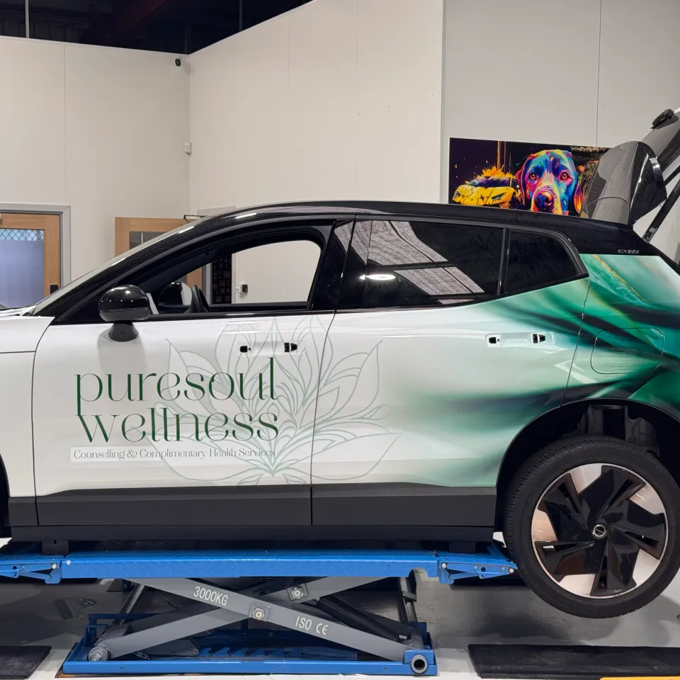 Puresoul Wellness lettering and floral graphics on a Volvo during wrap installation