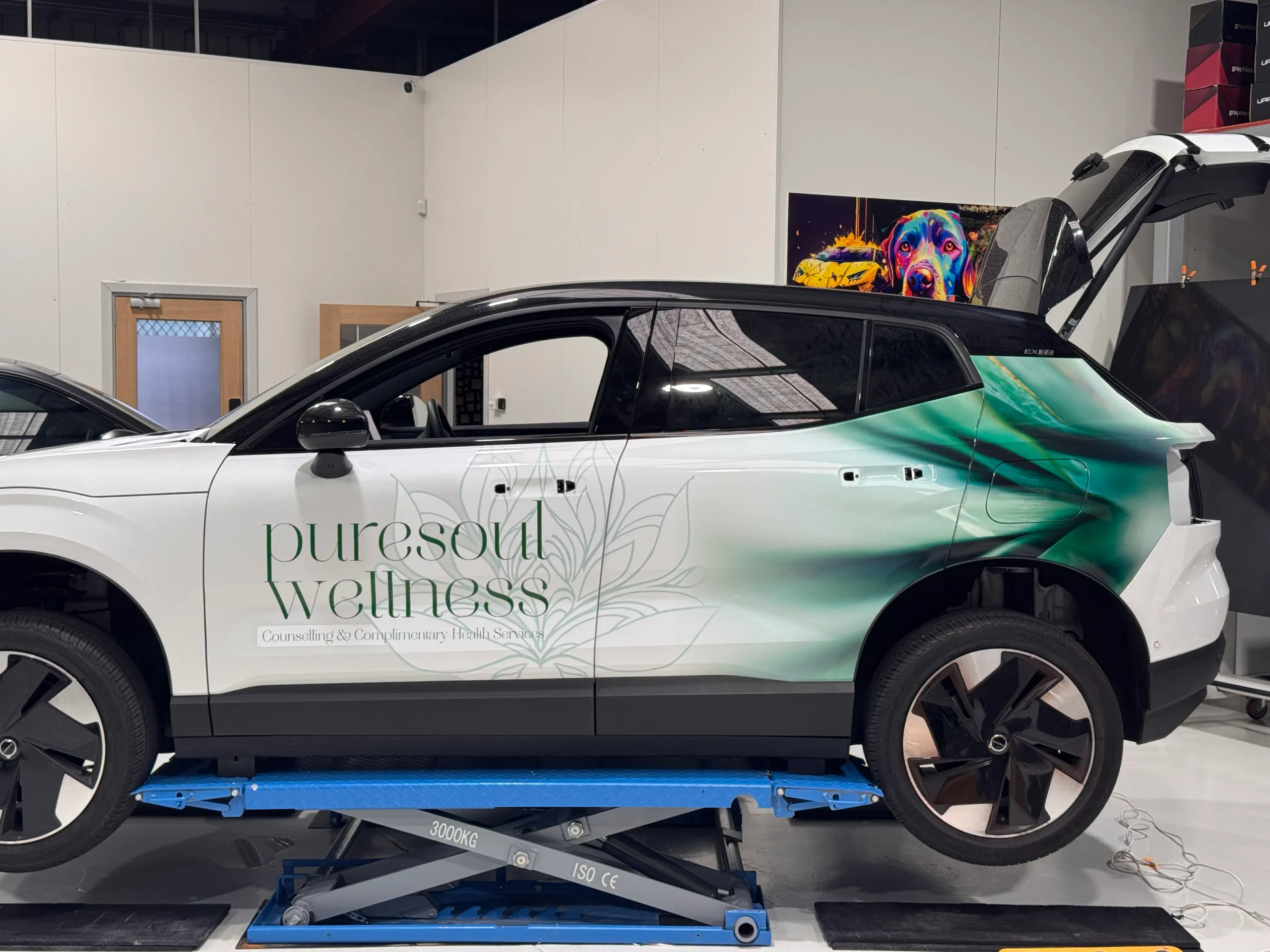 Puresoul Wellness lettering and floral graphics on a Volvo during wrap installation