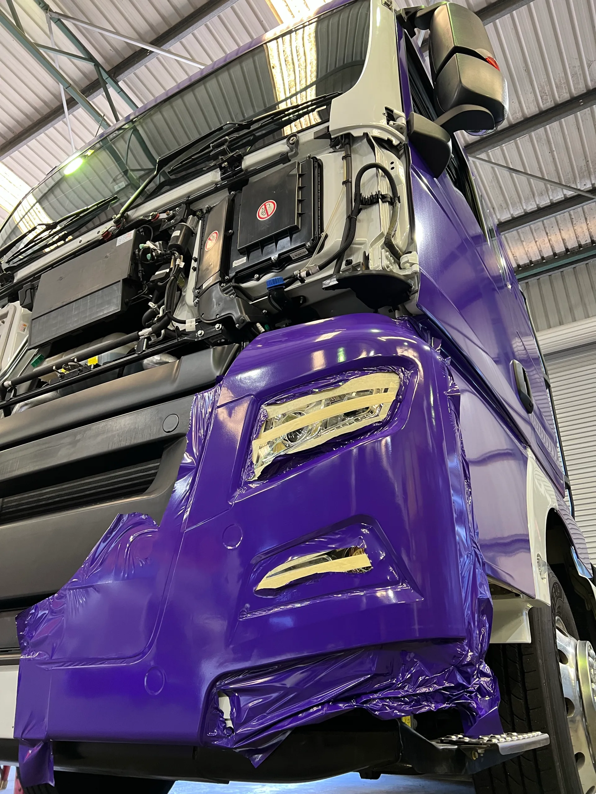 Disassembled truck cab during purple film installation