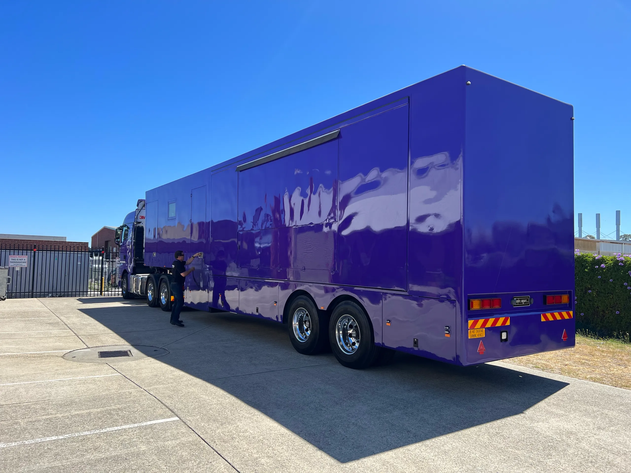 Completed purple exhibition trailer outside with a person nearby
