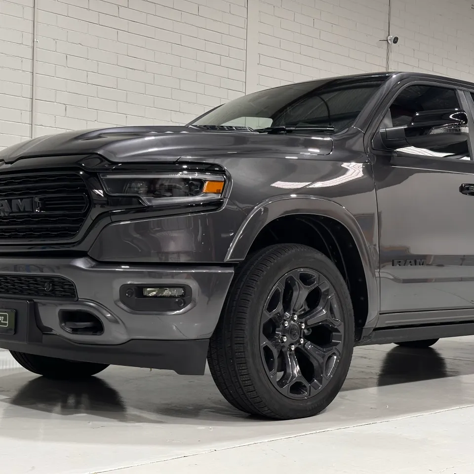 Low front-quarter view of the grey Ram 1500 grille, front wheel and cab